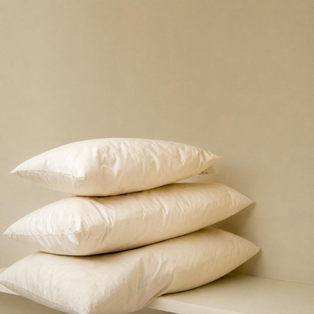 Close-up of cream rectangle cushion inserts stacked together