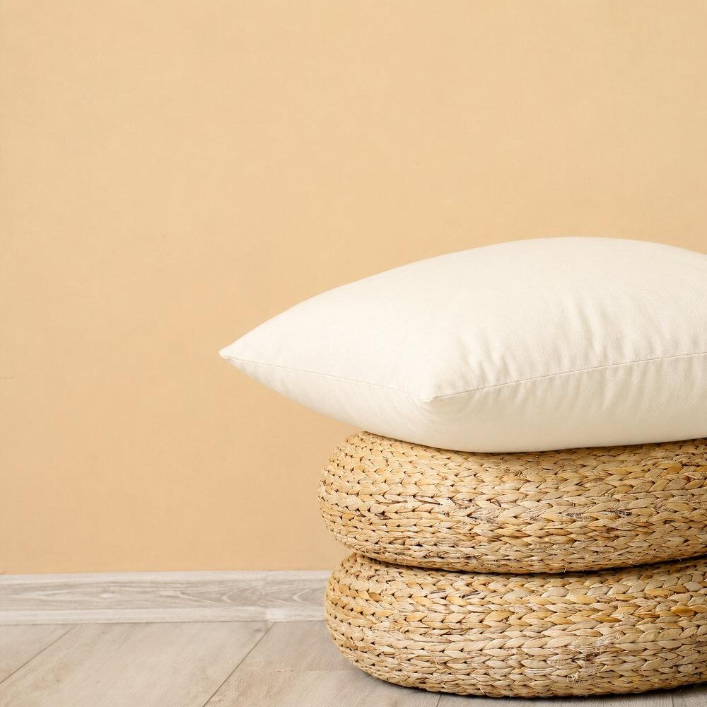 Floor cushion pad stacked on woven straw floor cushions
