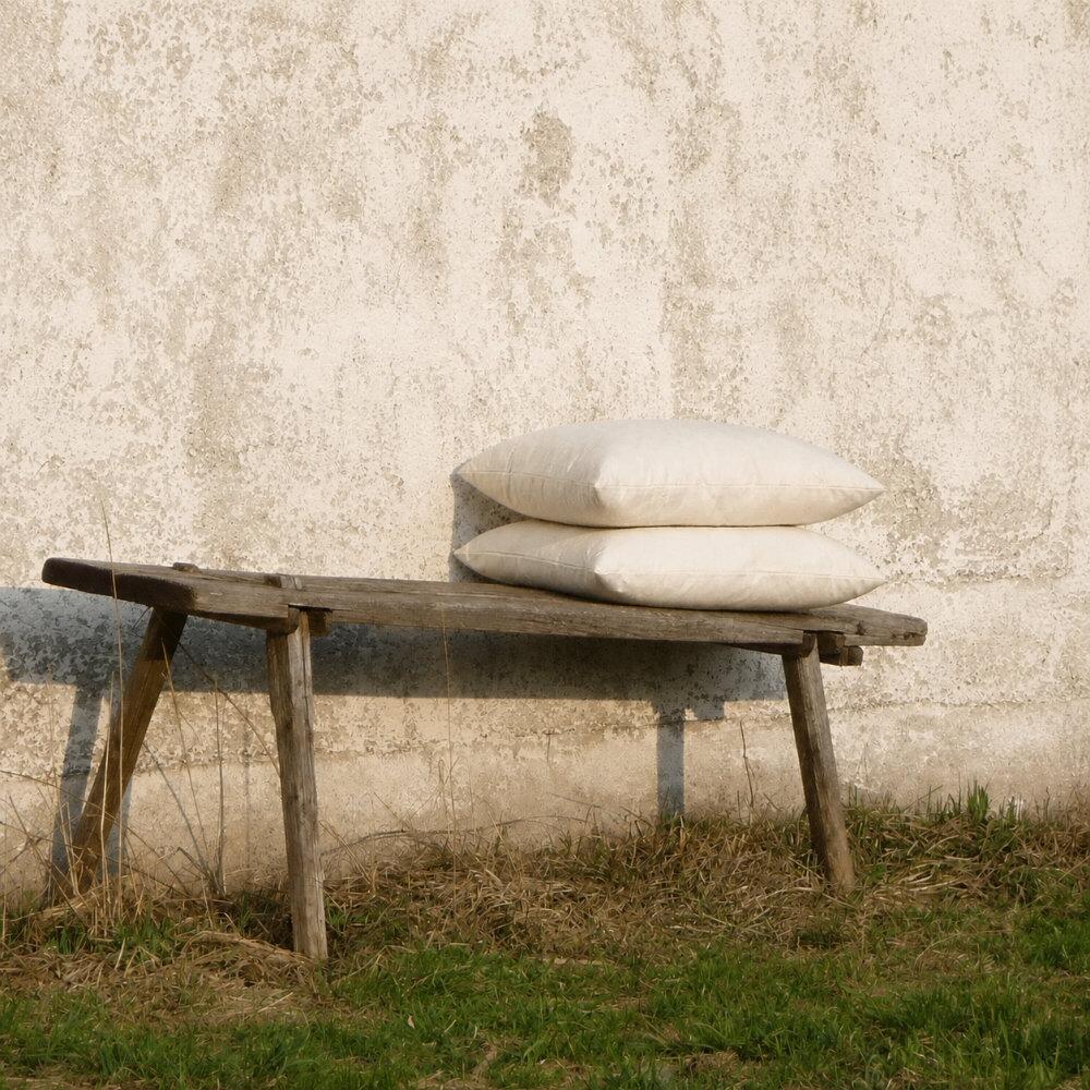 Square wool cushion pads styled on a wooden bench