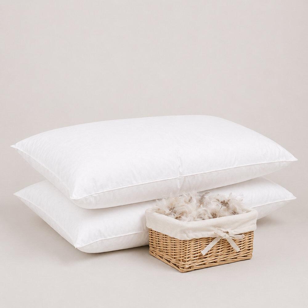 Pair of white feather pillows beside a basket of feather filling