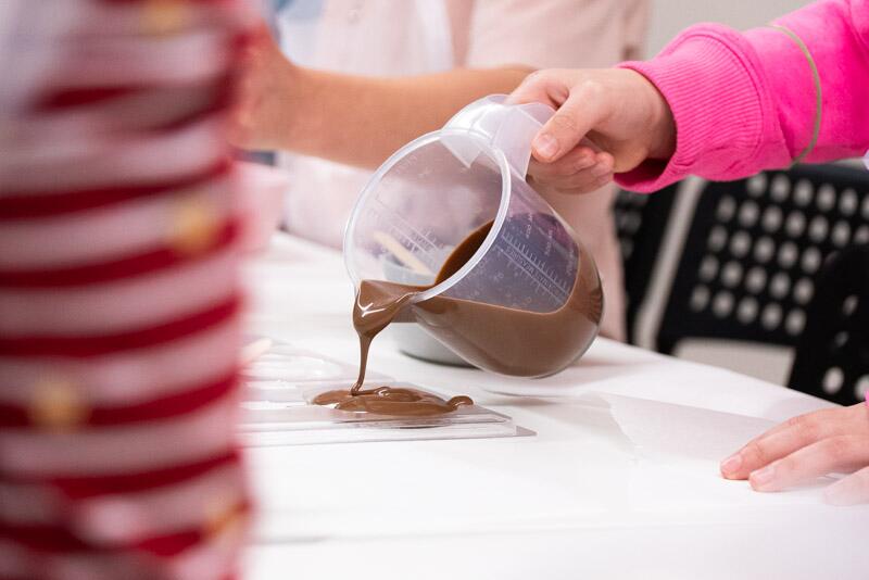 Children pouring melted Chocolate at a Choccotastic Workship