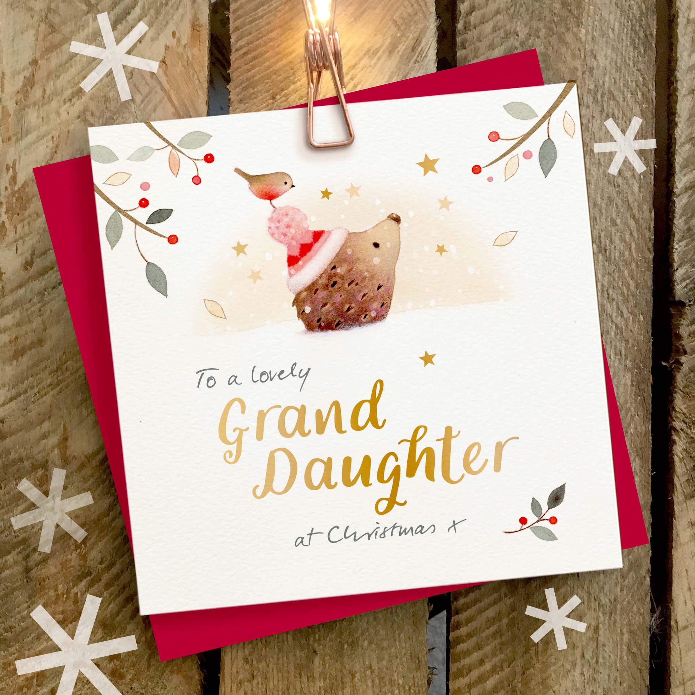 Christmas card featuring a large gold foil ‘GrandDaughter’ caption with a hedgehog and robin looking at a star.
