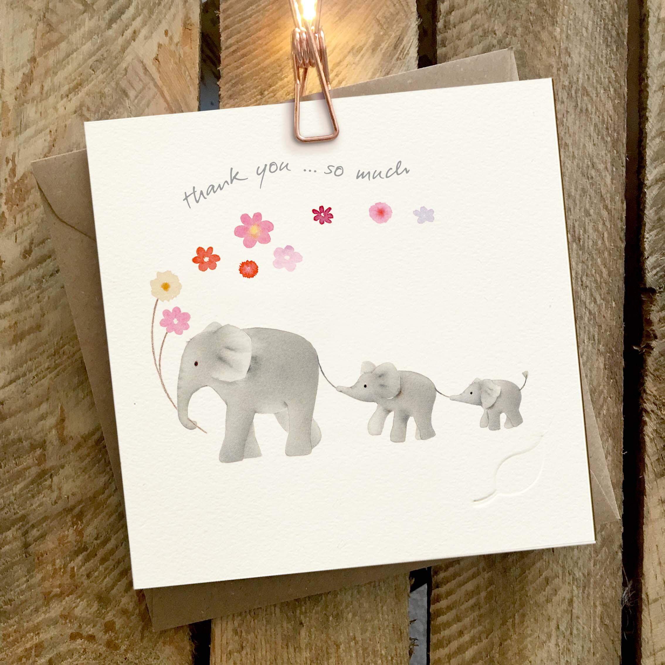 Elephant Family - Charity greeting card featuring a family of three elephants holding flowers and each other’s tails.