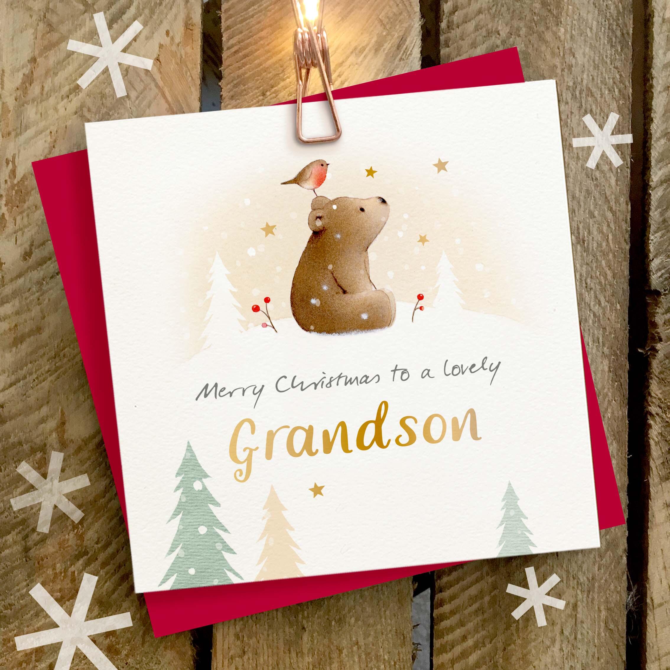 Christmas card featuring a large gold foil ‘Grandson’ caption and a brown bear with a robin on its head.