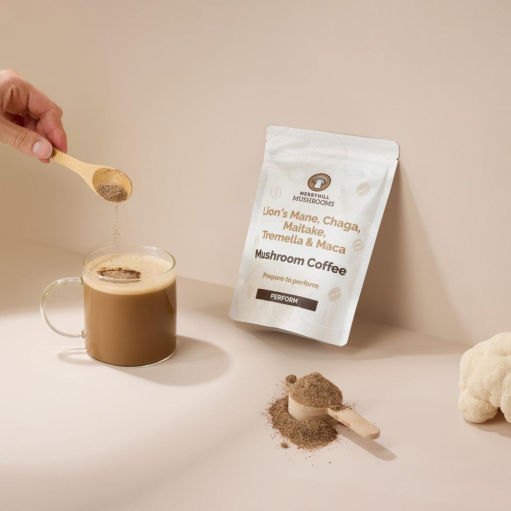 Perform mushroom coffee lifestyle image showing spoon of coffee into glass