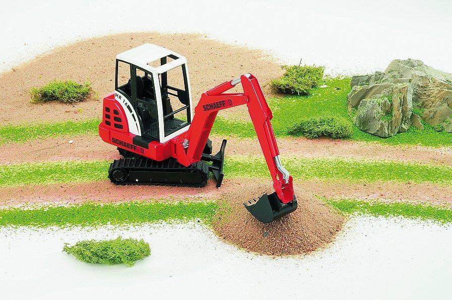 Bruder Schaeff HR16 mini excavator toy – digging in sand play scene
