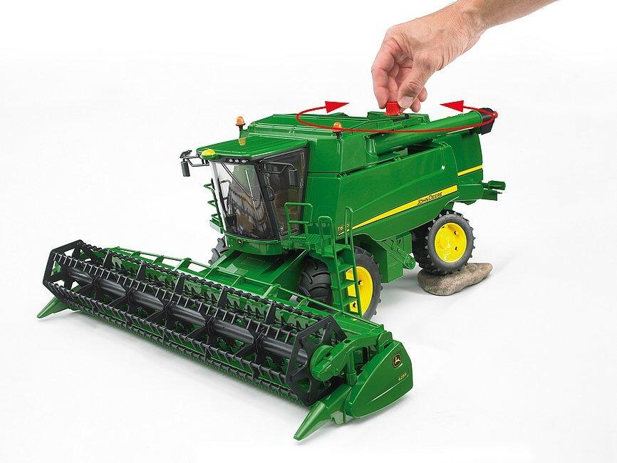 Child operating the rotating reel on a Bruder John Deere T670i combine toy