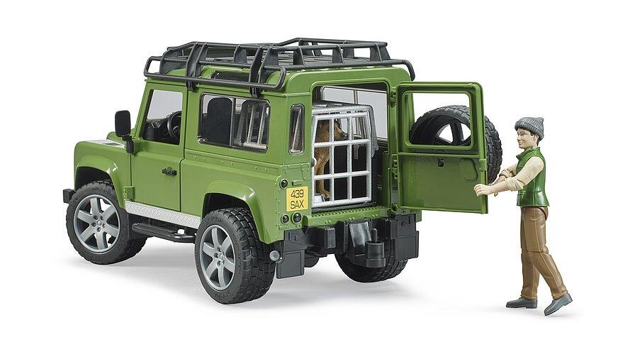 Green Land Rover model with rear door open and dog standing nearby