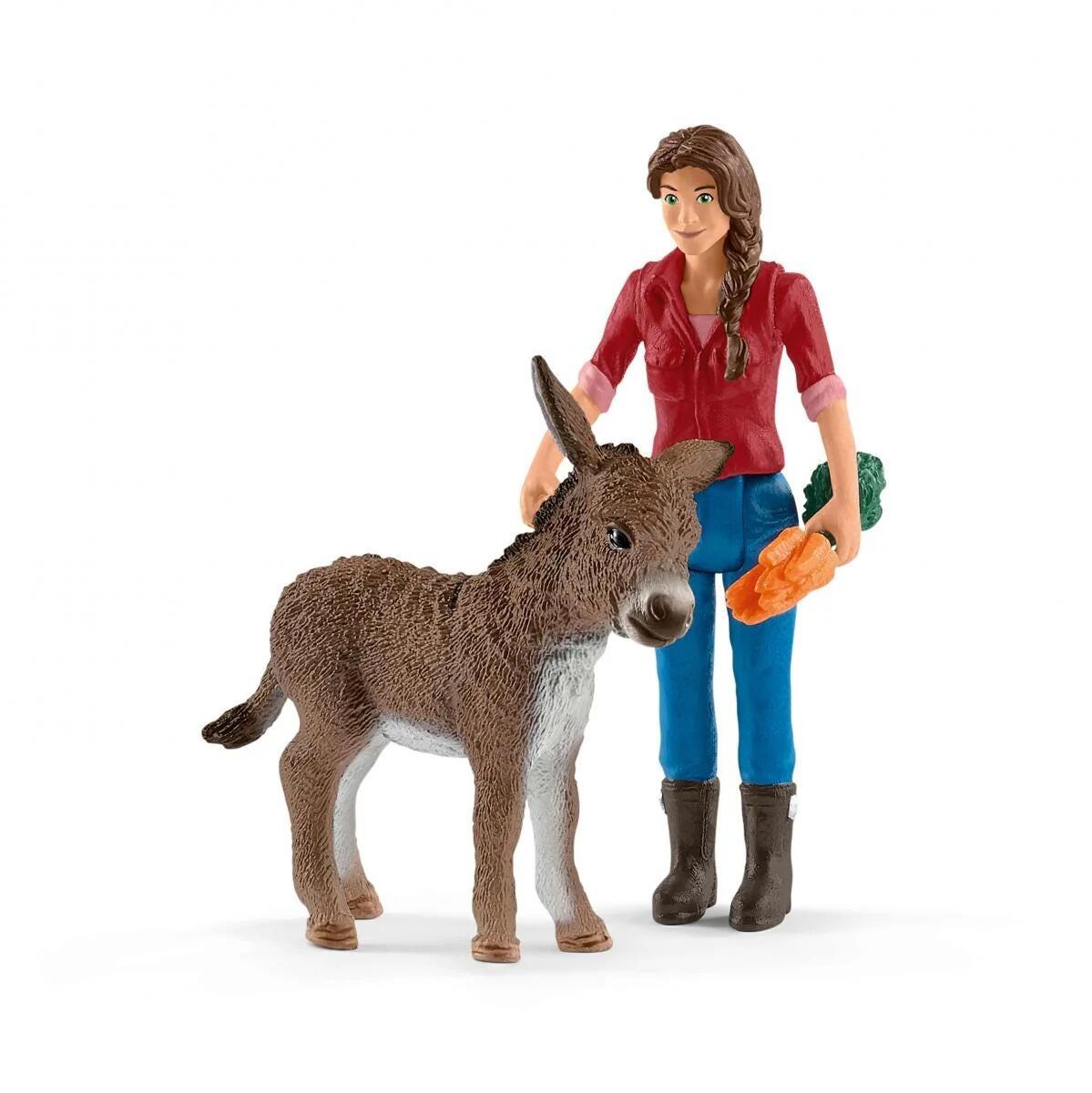 Schleich farmer figure standing beside a donkey foal from the Large Farm House set.