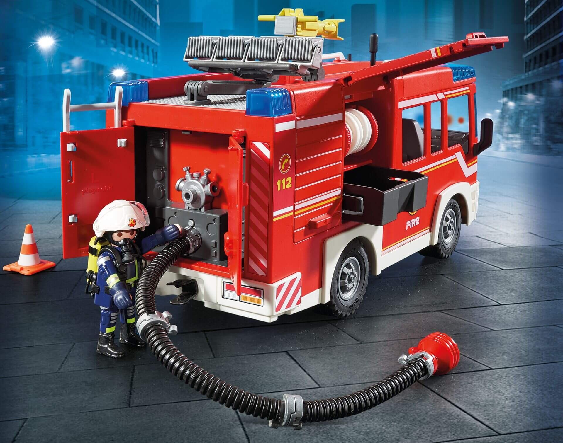 Firefighter figure using hose at the rear of the Playmobil fire engine