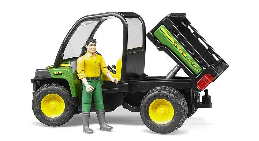 Bruder John Deere Gator XUV 855D toy with driver standing next to the vehicle and the rear cargo bed tipped up