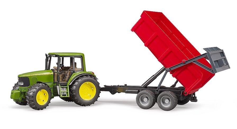 Side view of Bruder John Deere 6920 toy tractor with raised red tipping trailer
