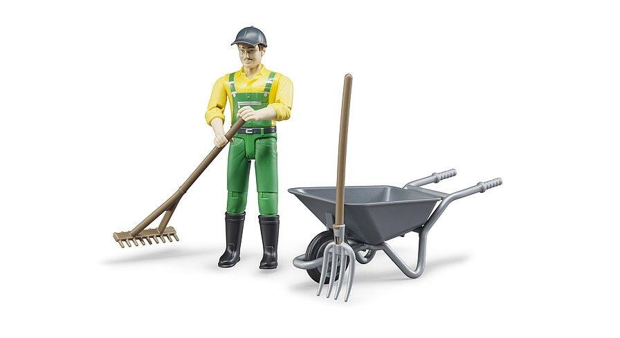 Farmer toy figure holding a rake beside a wheelbarrow with tools