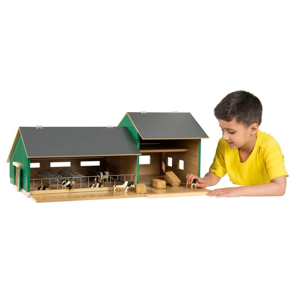 Front open view of cattle and machinery shed, with child looking into the farm set up.