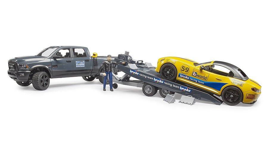 Side view of Bruder RAM 2500 Power Wagon with racing trailer and yellow roadster toy