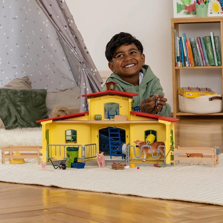 Child playing with the Schleich Large Farm 42605 set on a tabletop.