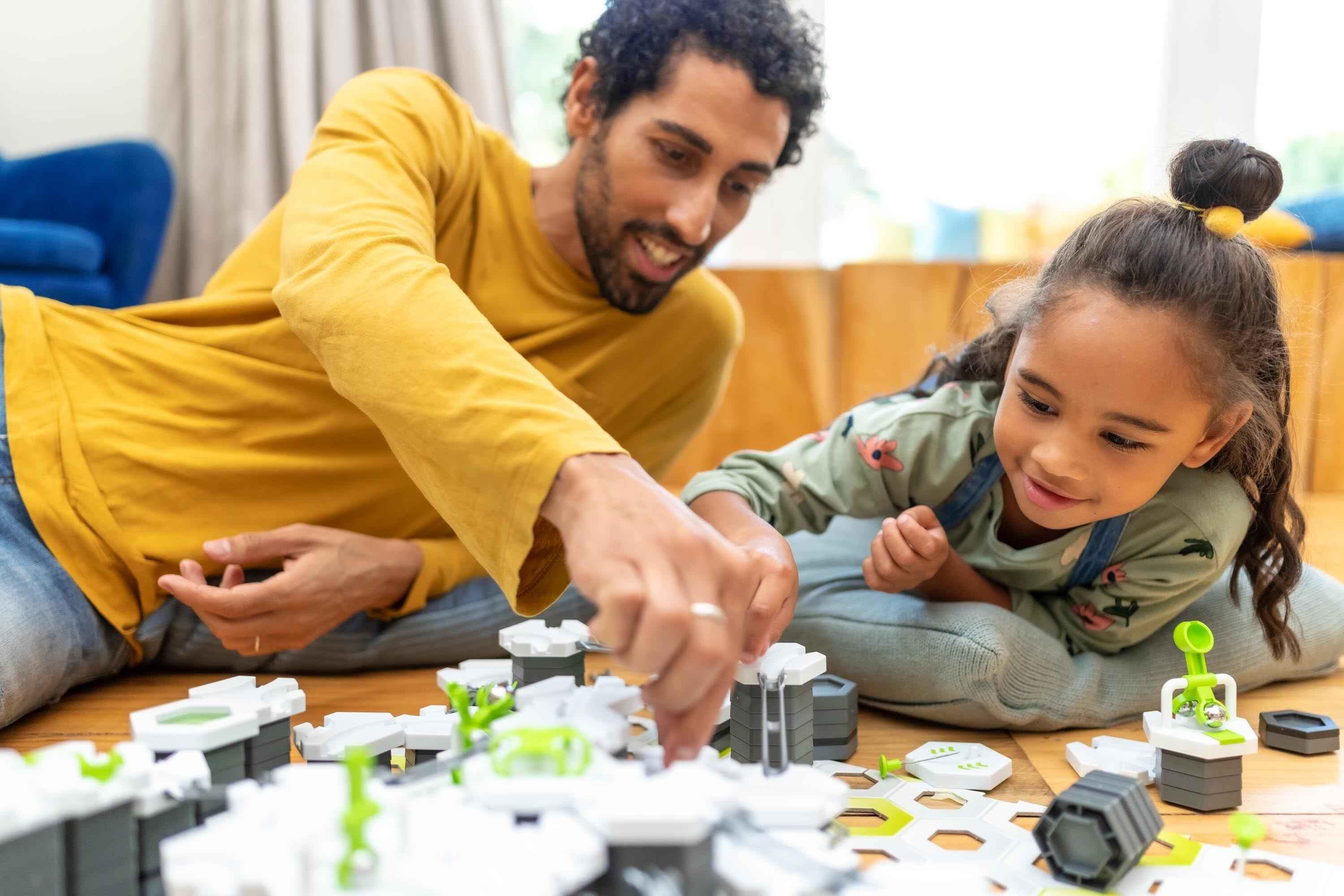 Parent and child playing together with a GraviTrax marble run set