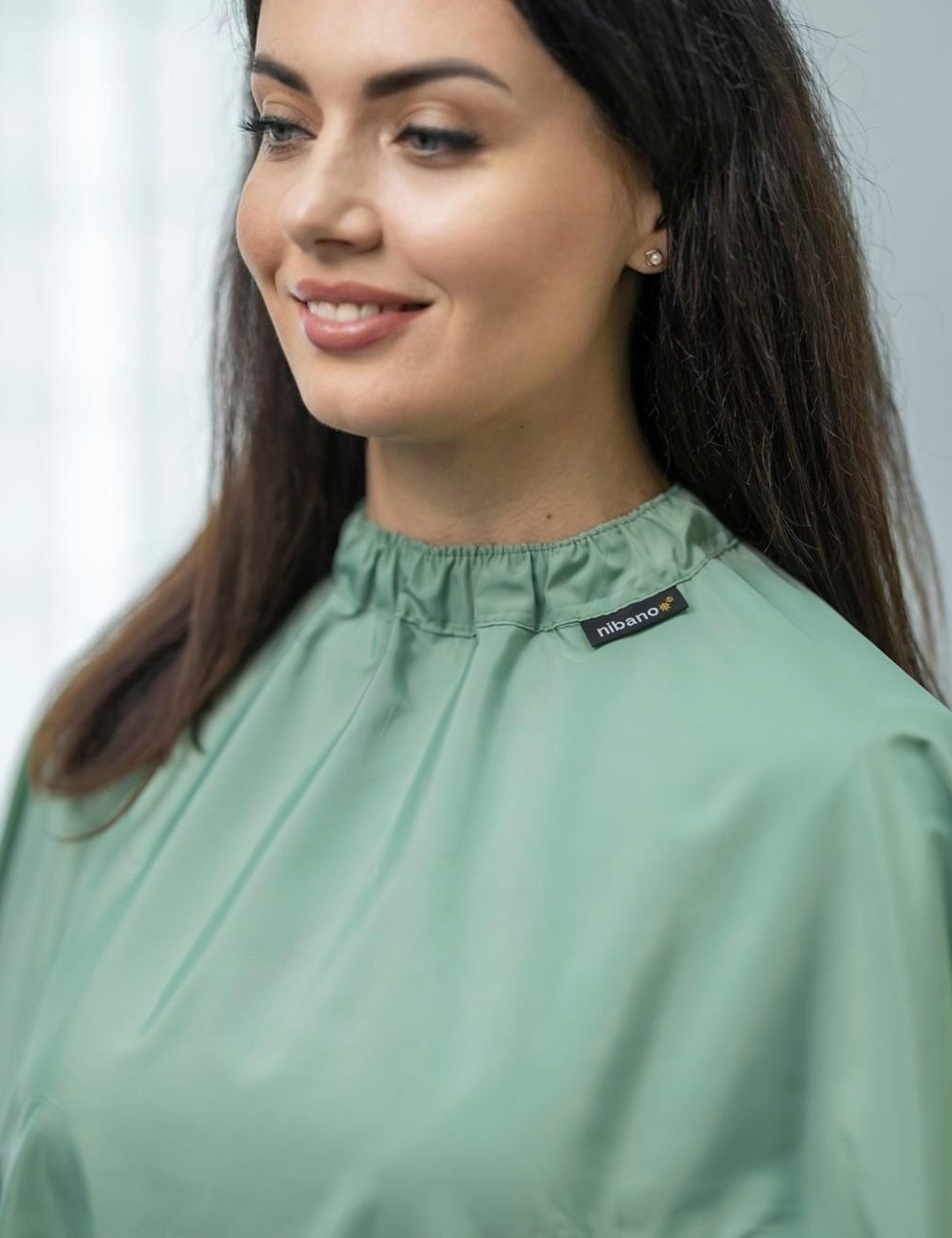 Custom branded olive salon cape displaying a personalized hairdresser logo
