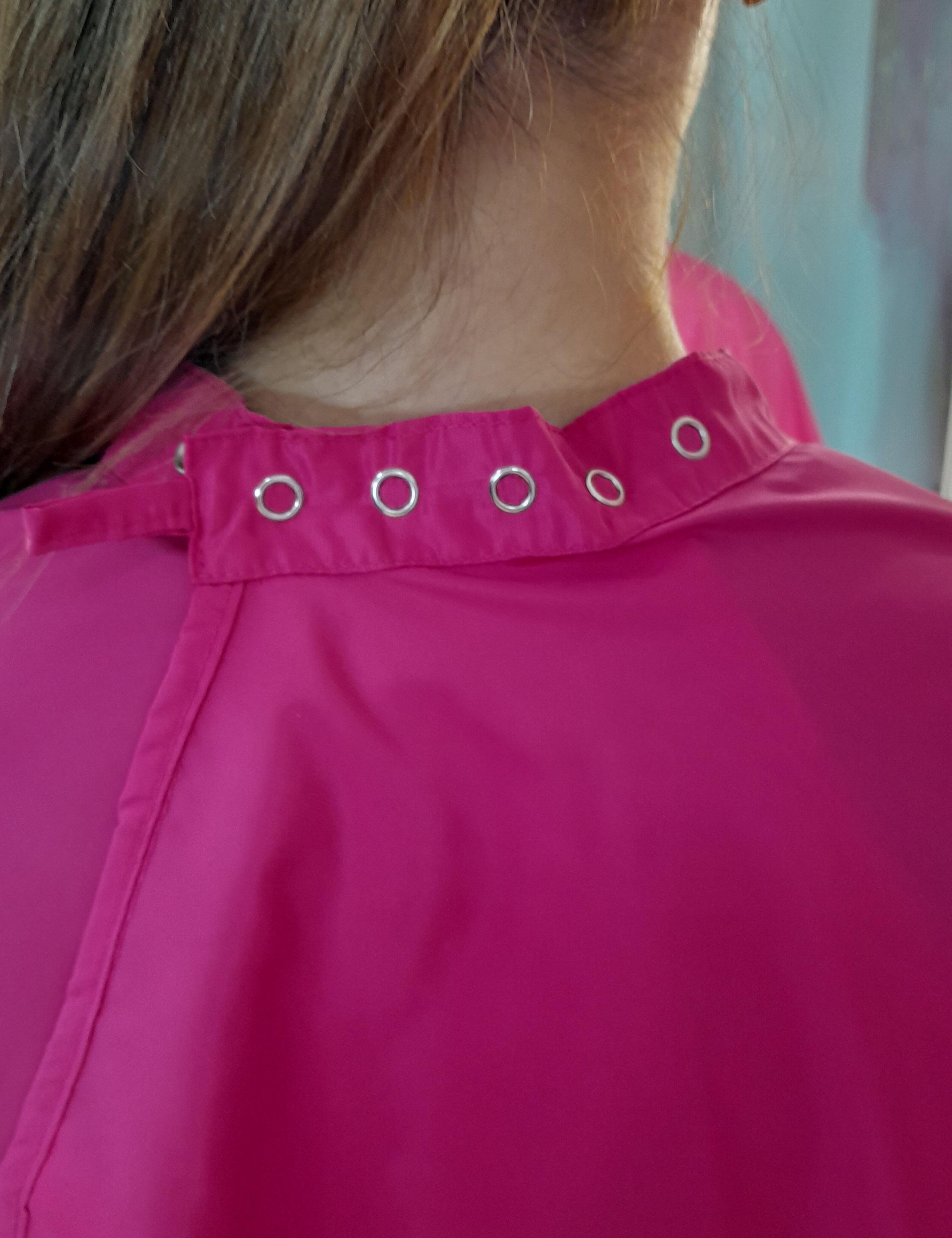 Hot pink styling cape outfitted with durable heavy-duty snap fasteners.