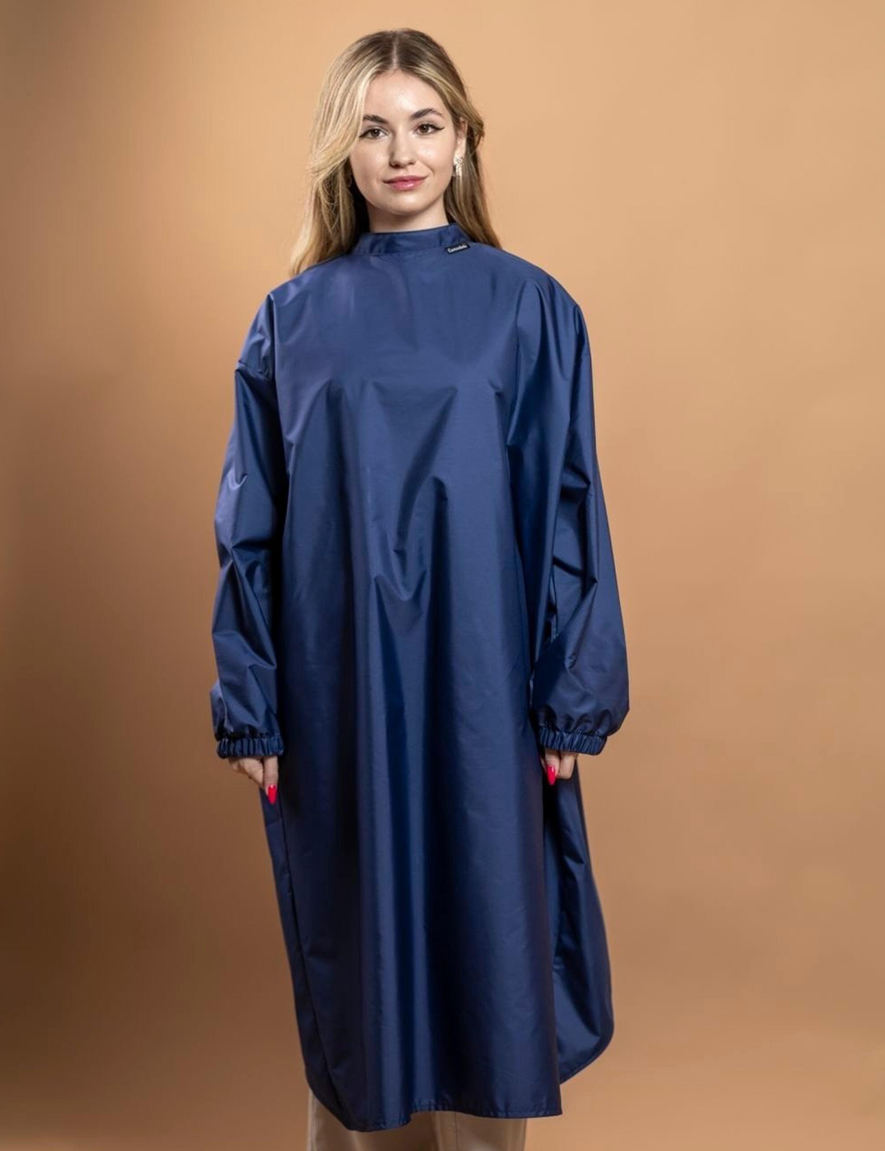 Ergonomic navy blue client cape with sleeves providing a luxury mess-free experience for high-end US styling services