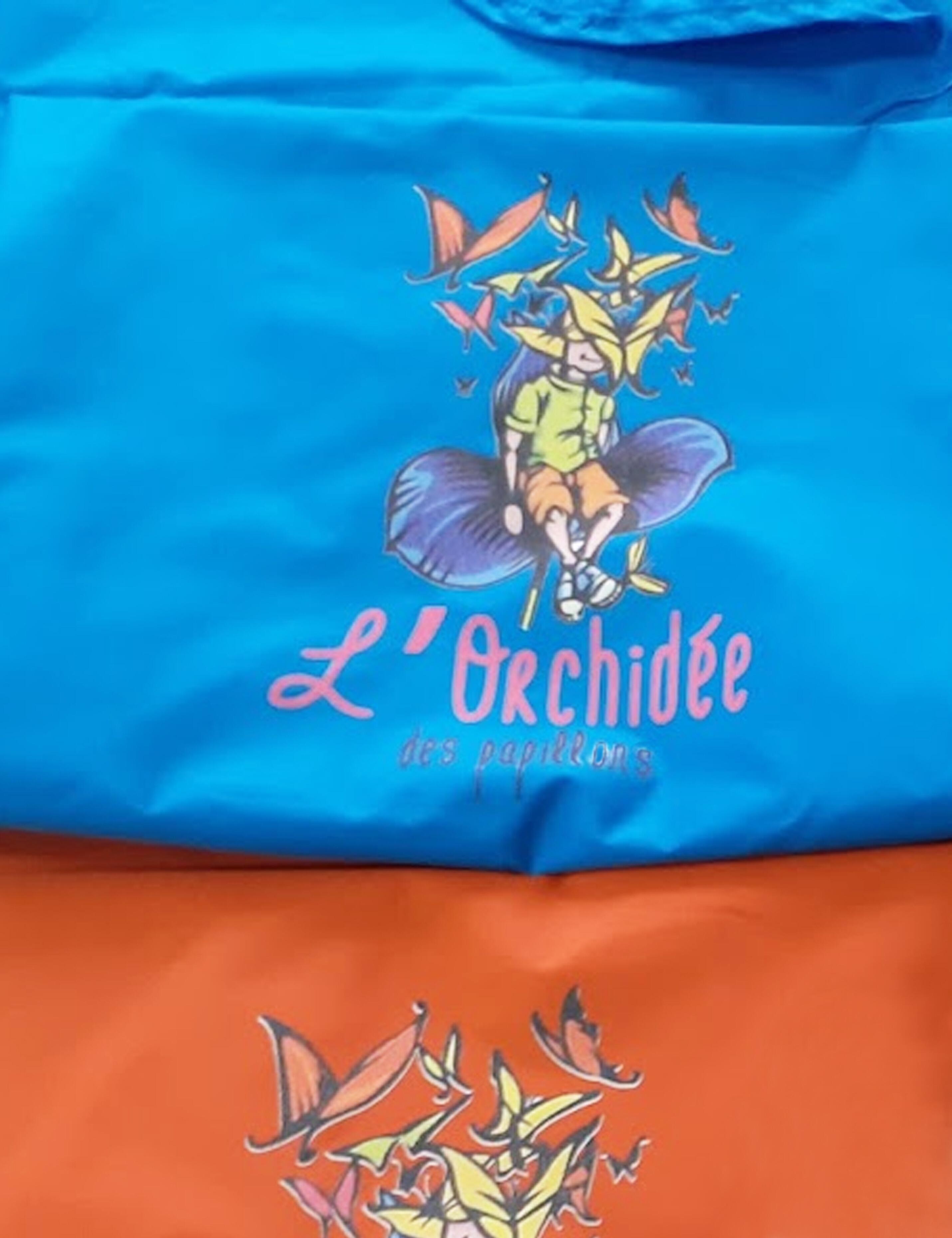 Custom printed turquoise salon cape with a personalized hairdresser logo.