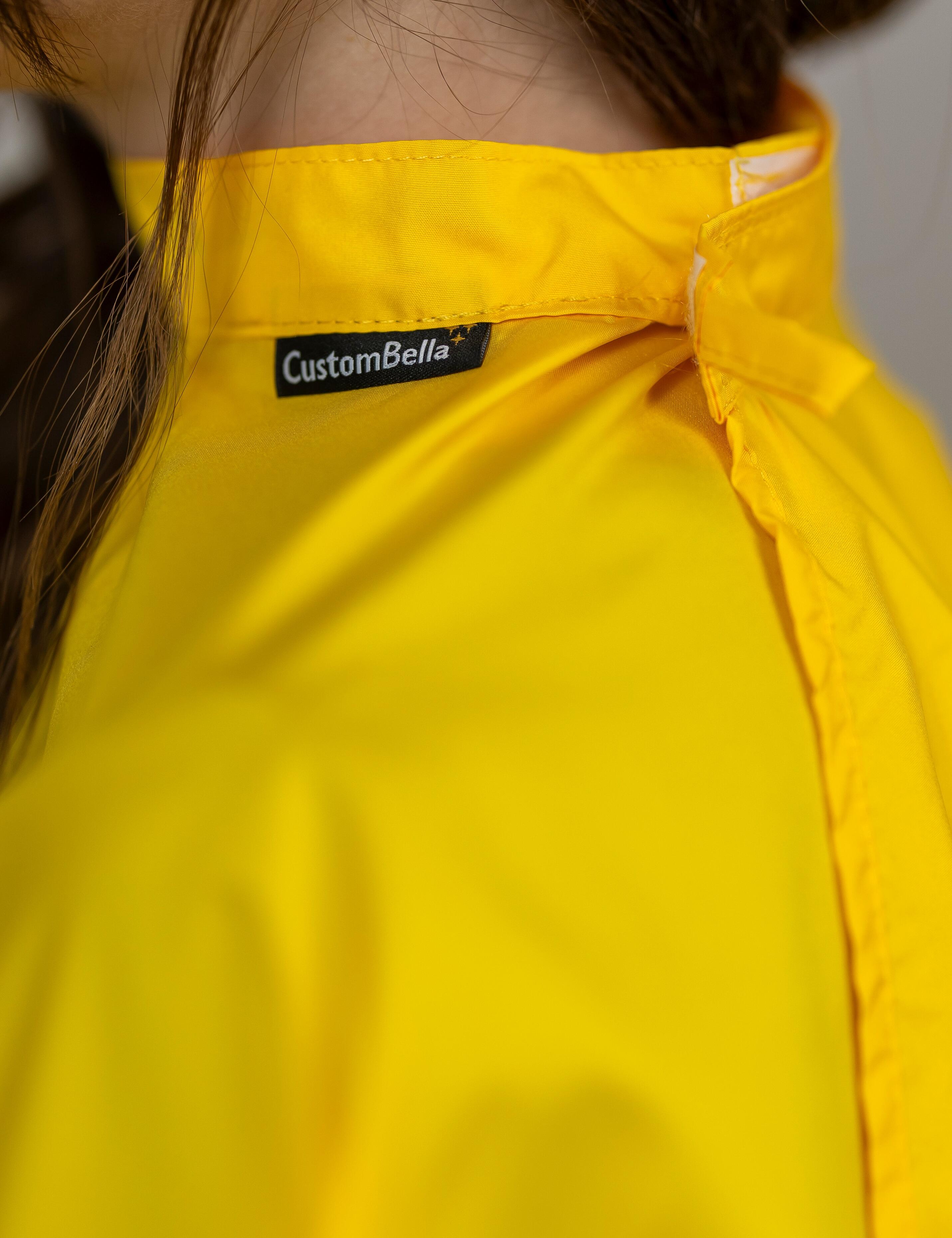 Yellow shaded salon cover protecting children's clothes during hair cutting