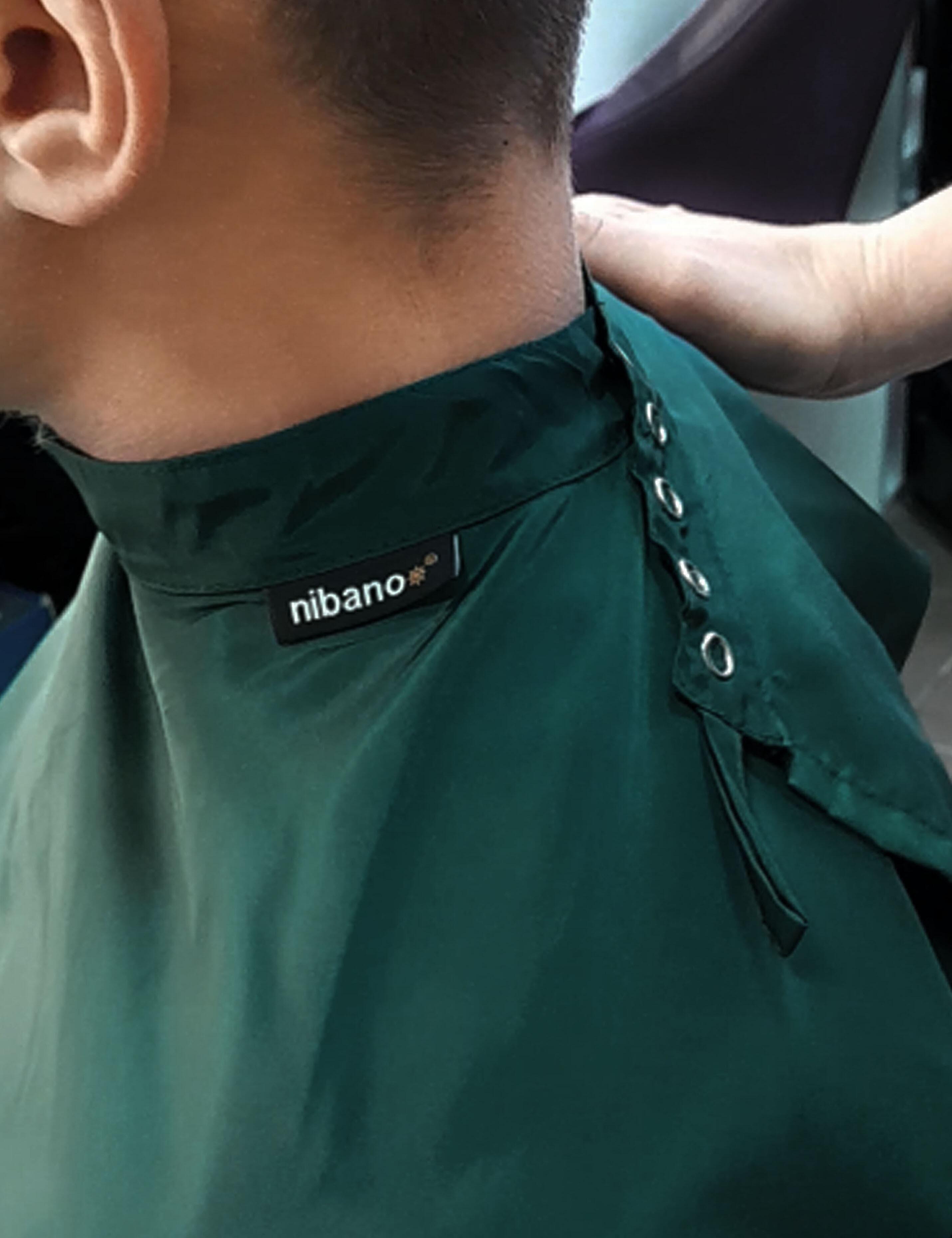 Bottle green salon cape with adjustable snap closures for a secure neck fit
