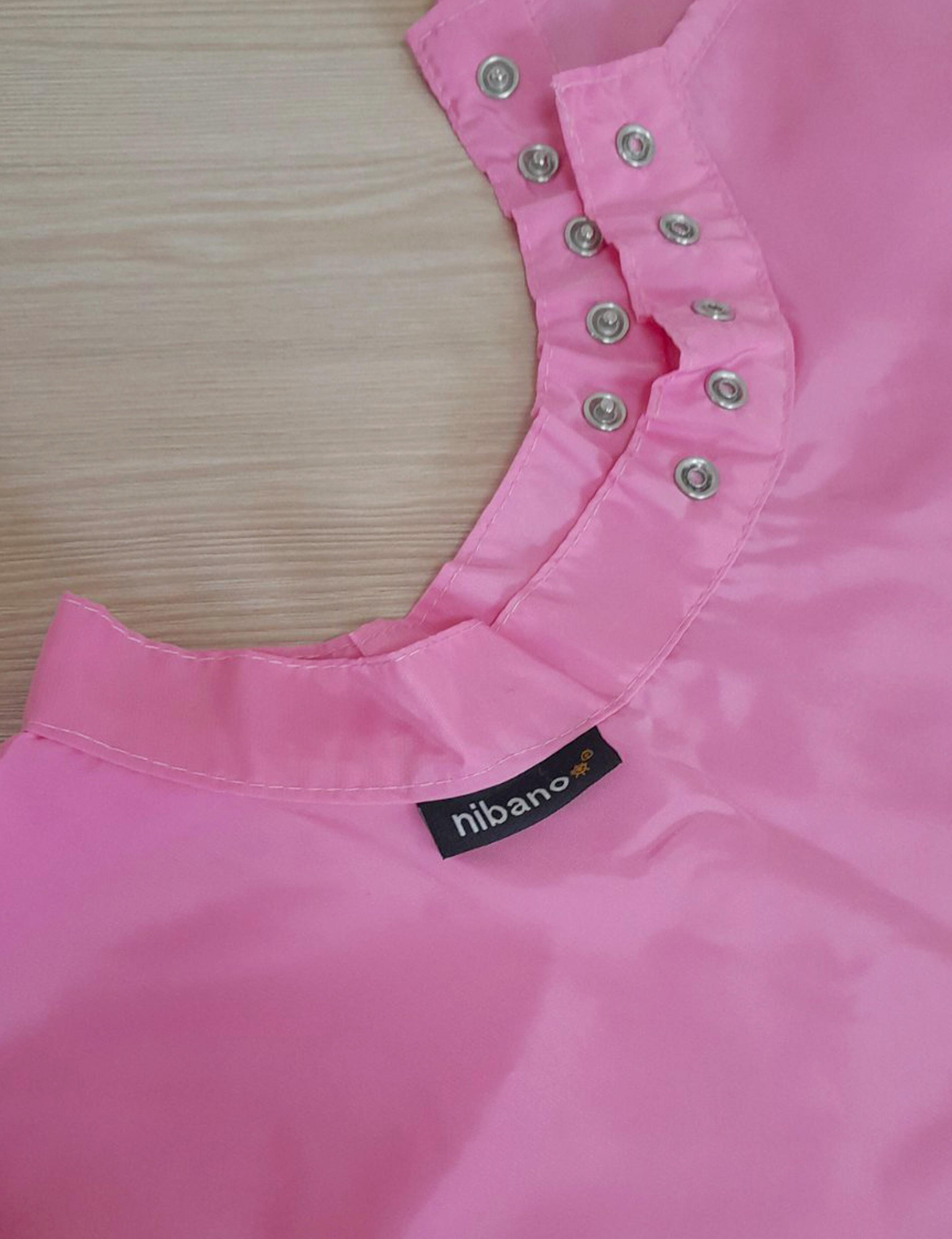 Pink barbie styling cape equipped with adjustable snap closures.
