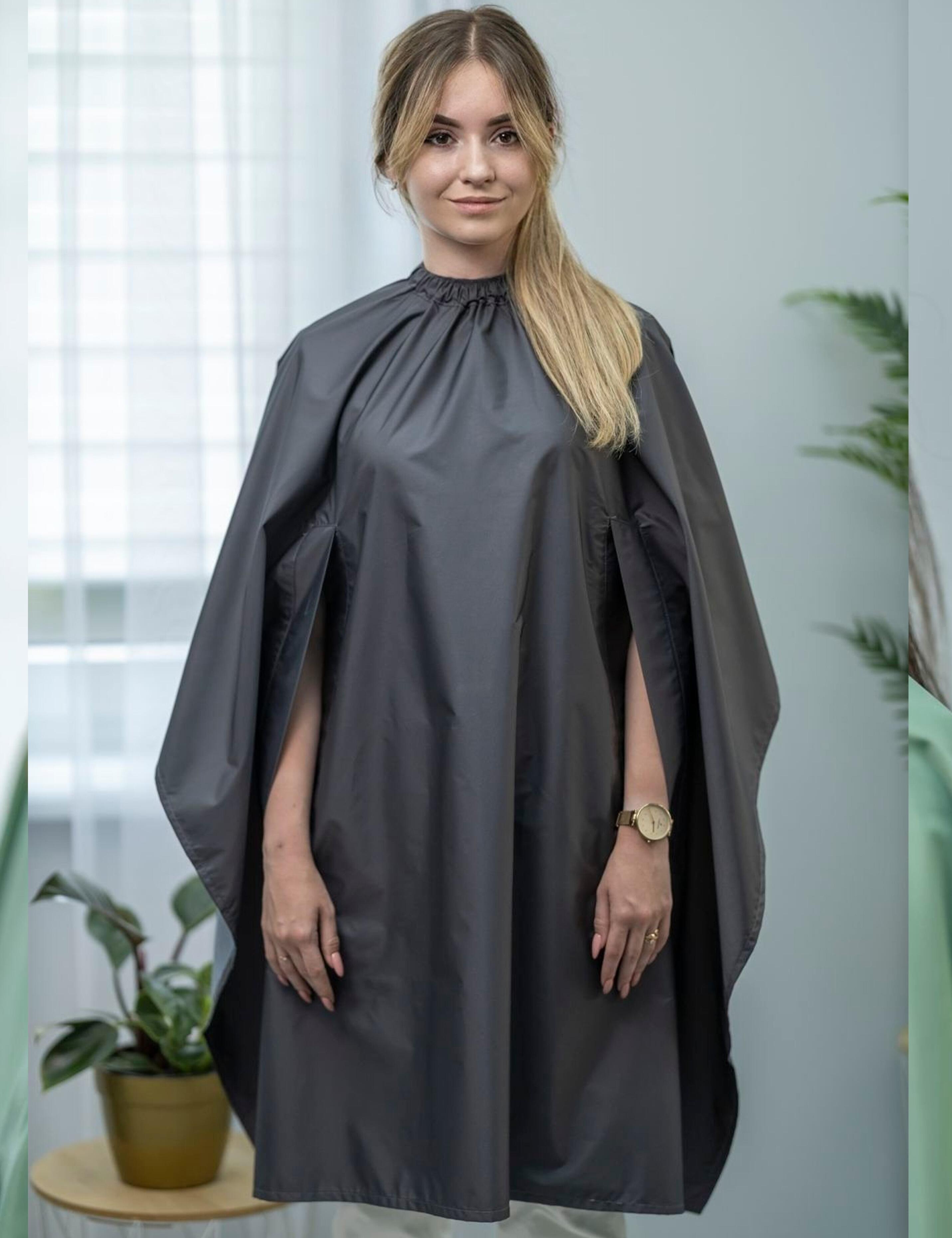 Dark grey salon drape with hand slots protecting clothing during styling
