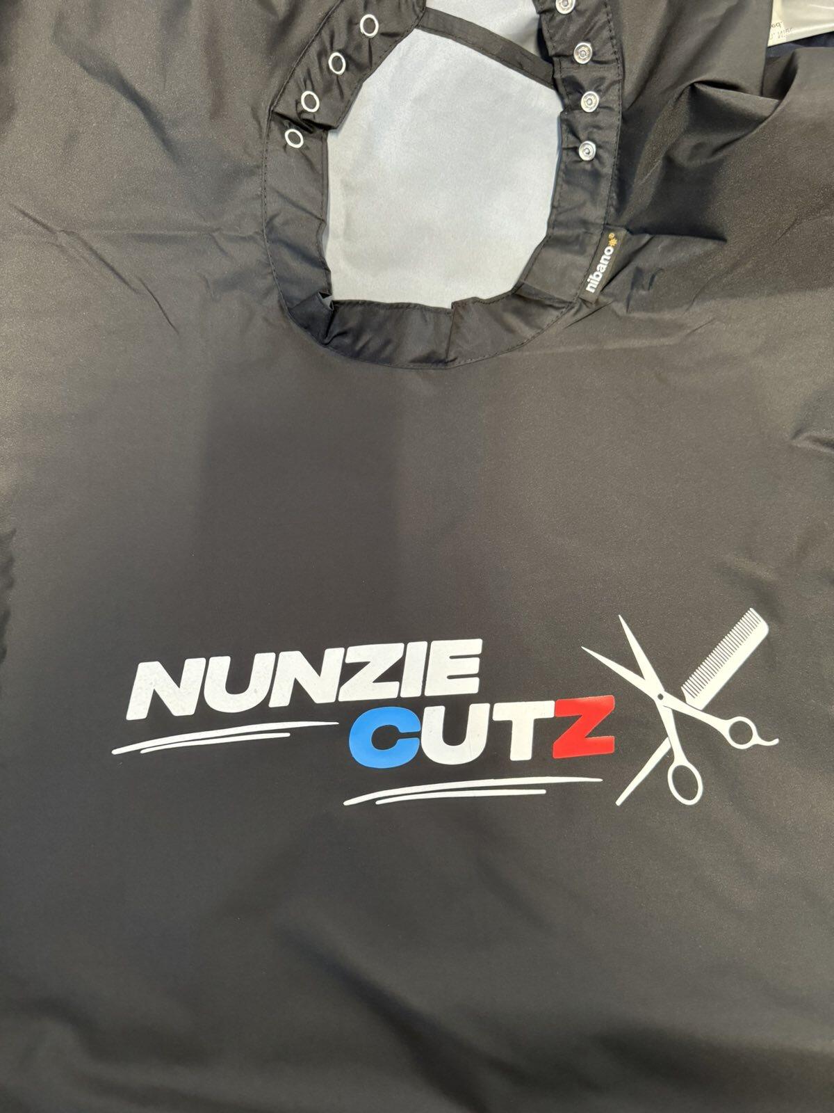 Close-up of a high-quality printed logo on a black barber cape