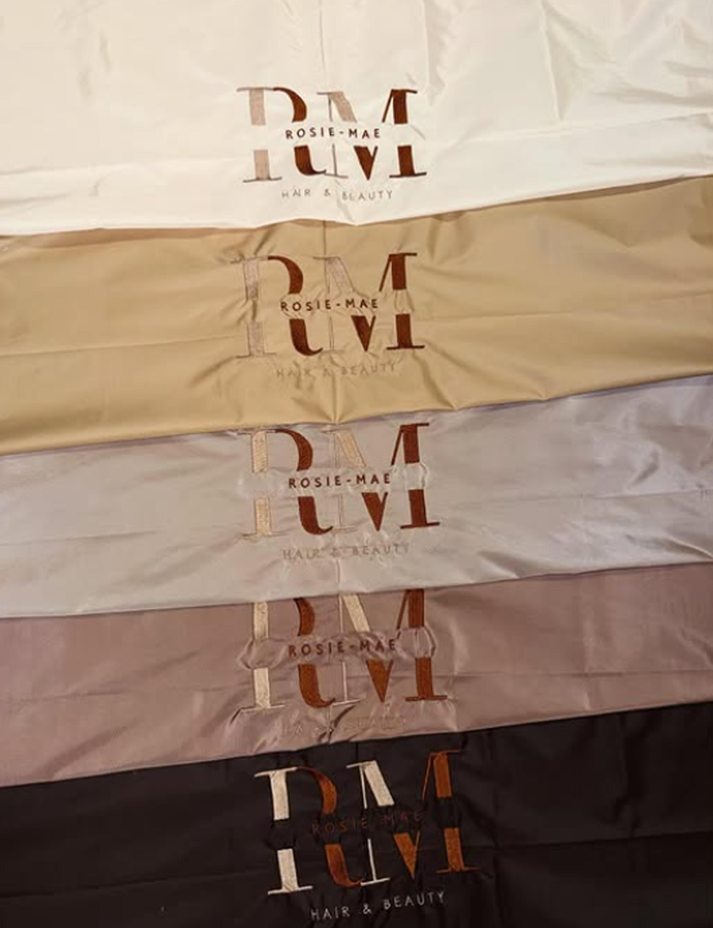 Classy cappuccino salon cape customized with a high-thread embroidery design