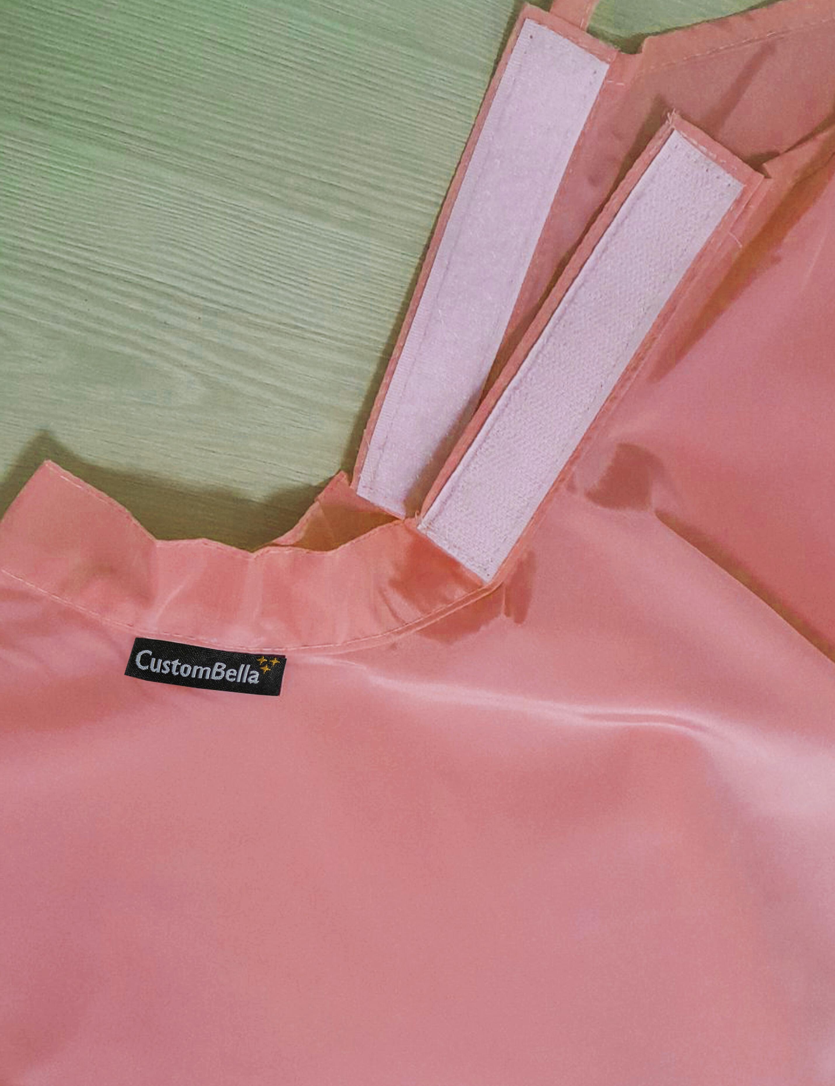 Peach color kids salon cape with a flexible velcro neck fastener