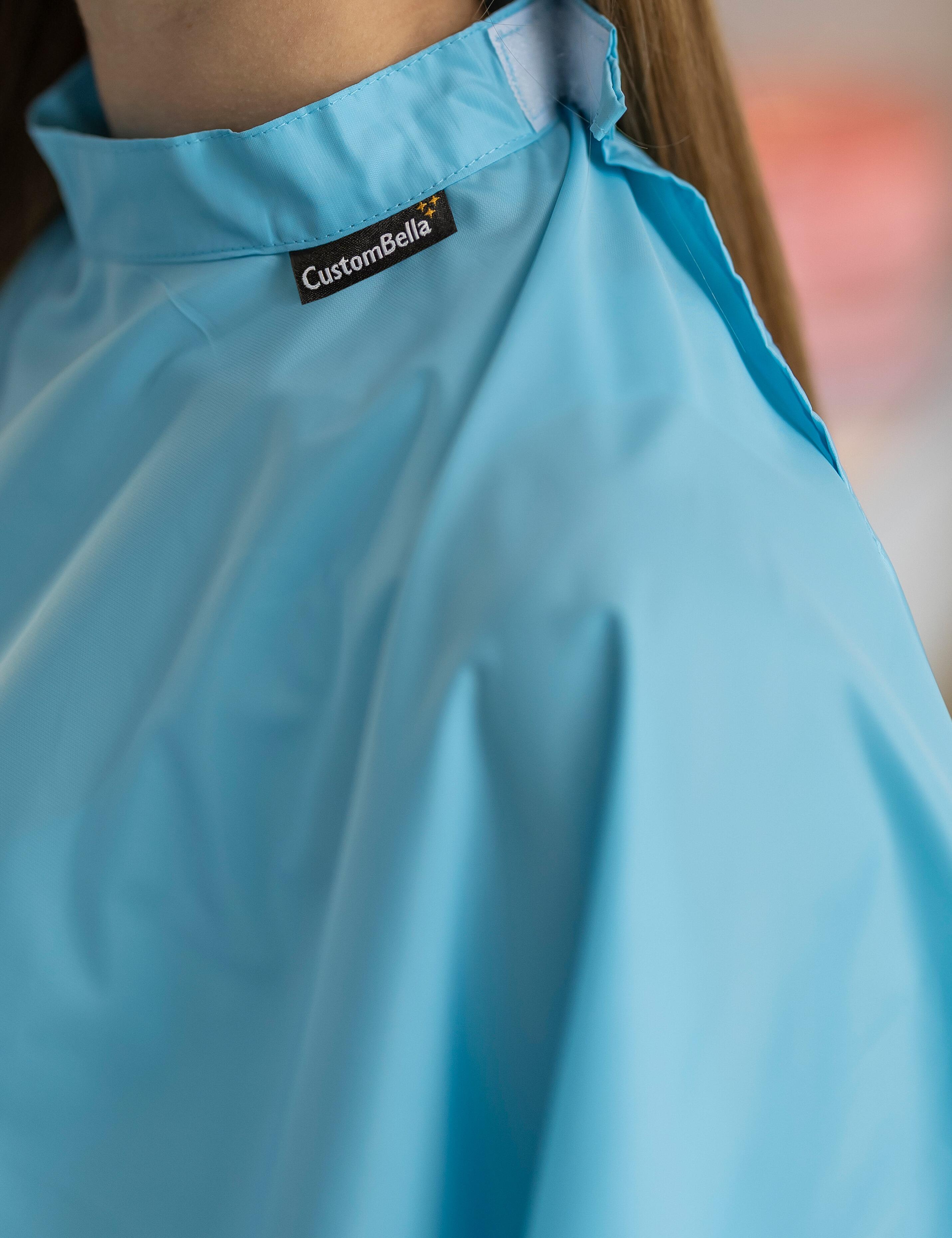 Aqua blue kids salon cape with an adjustable velcro neck closure
