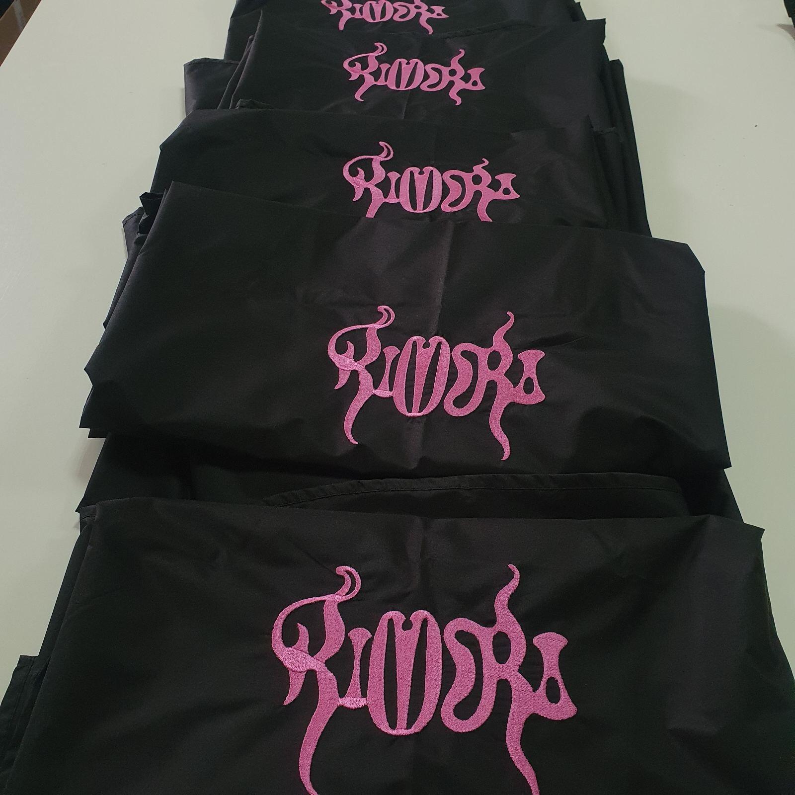 Close-up of a personalized embroidered logo on a black cape