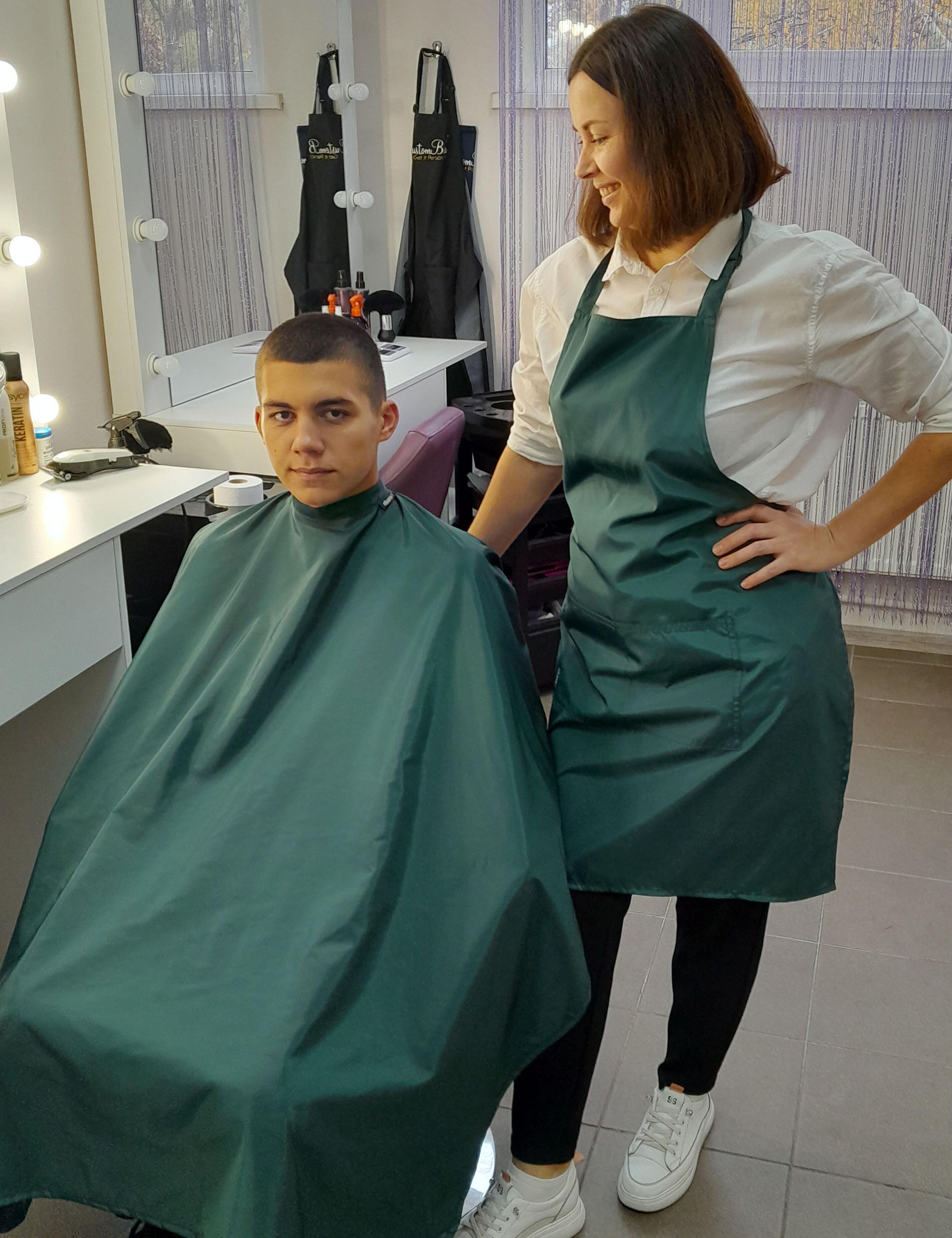 Water-resistant bottle green salon cape available for fast shipping across the USA