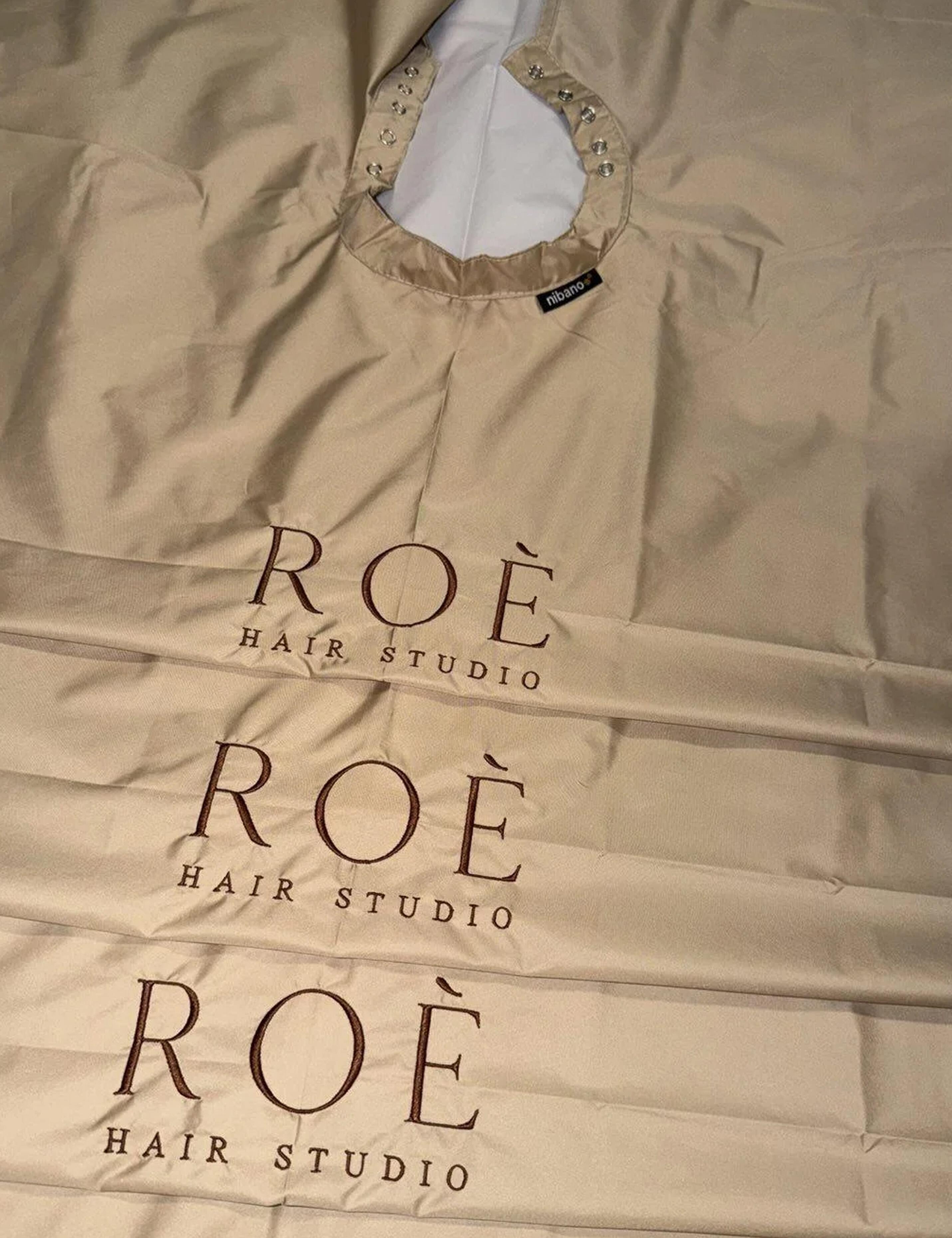 High-end cappuccino barber cape customized with elegant thread embroidery