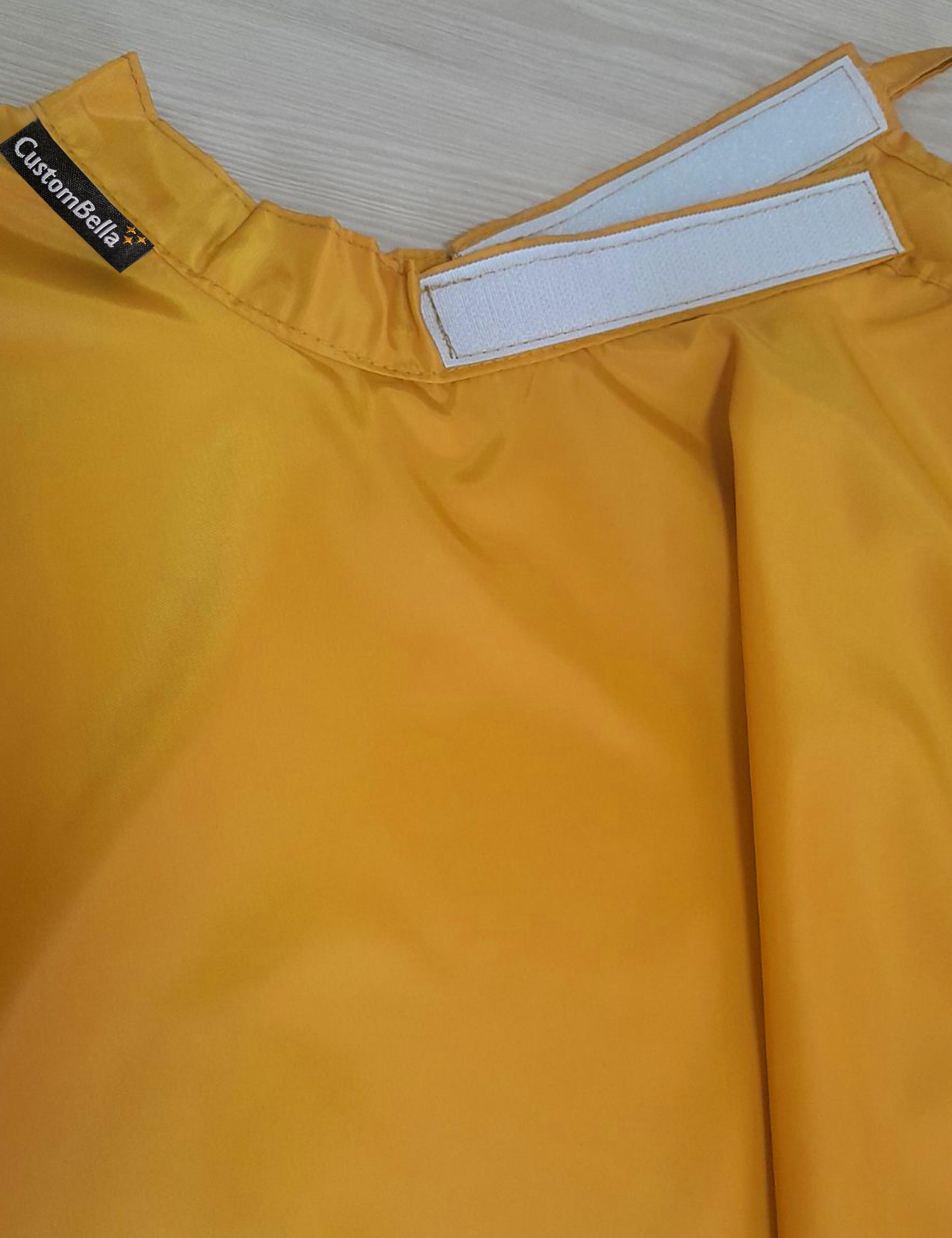 Mustard kids salon cape with an adjustable velcro neck closure