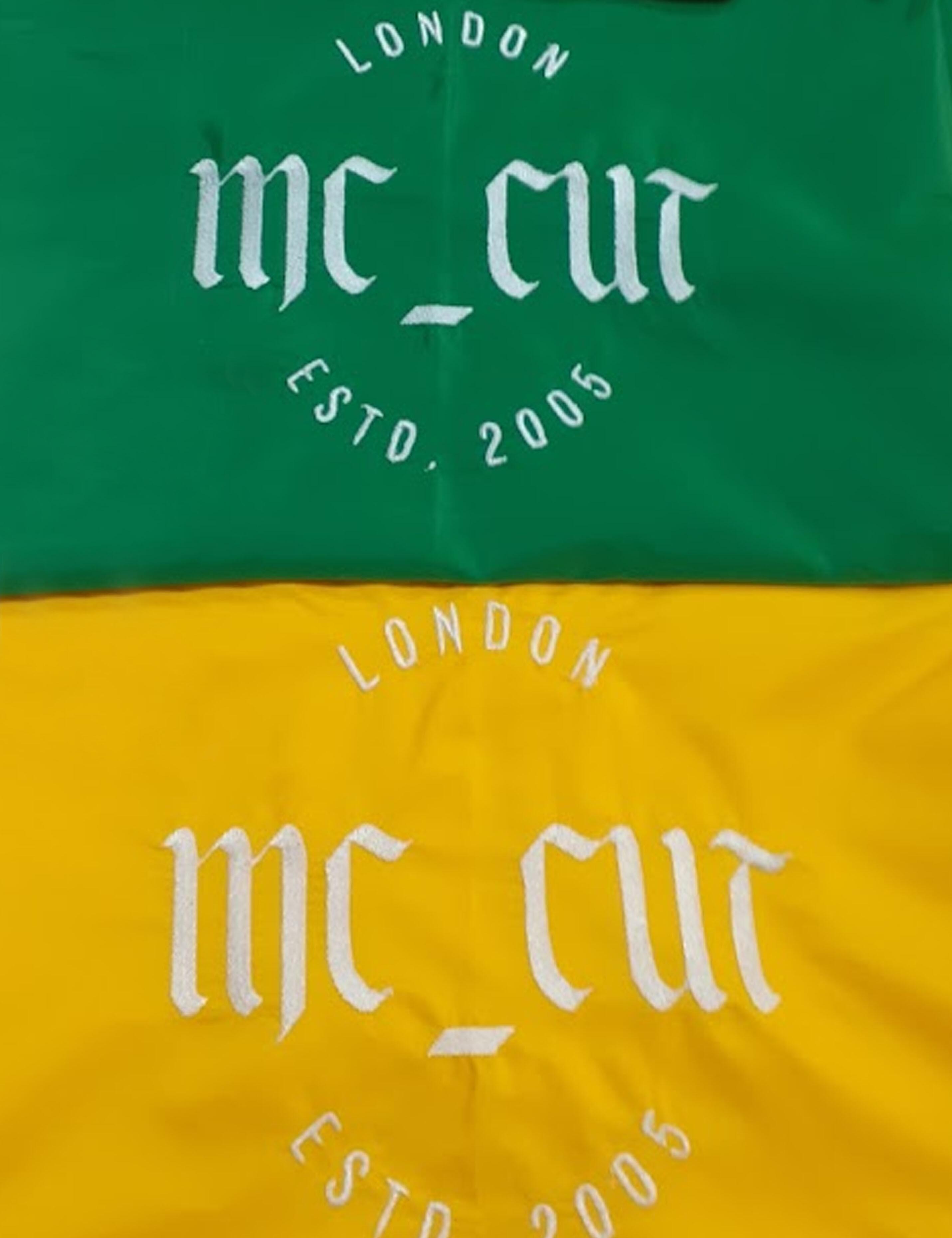 Custom kelly green salon cape featuring a printed logo on the front