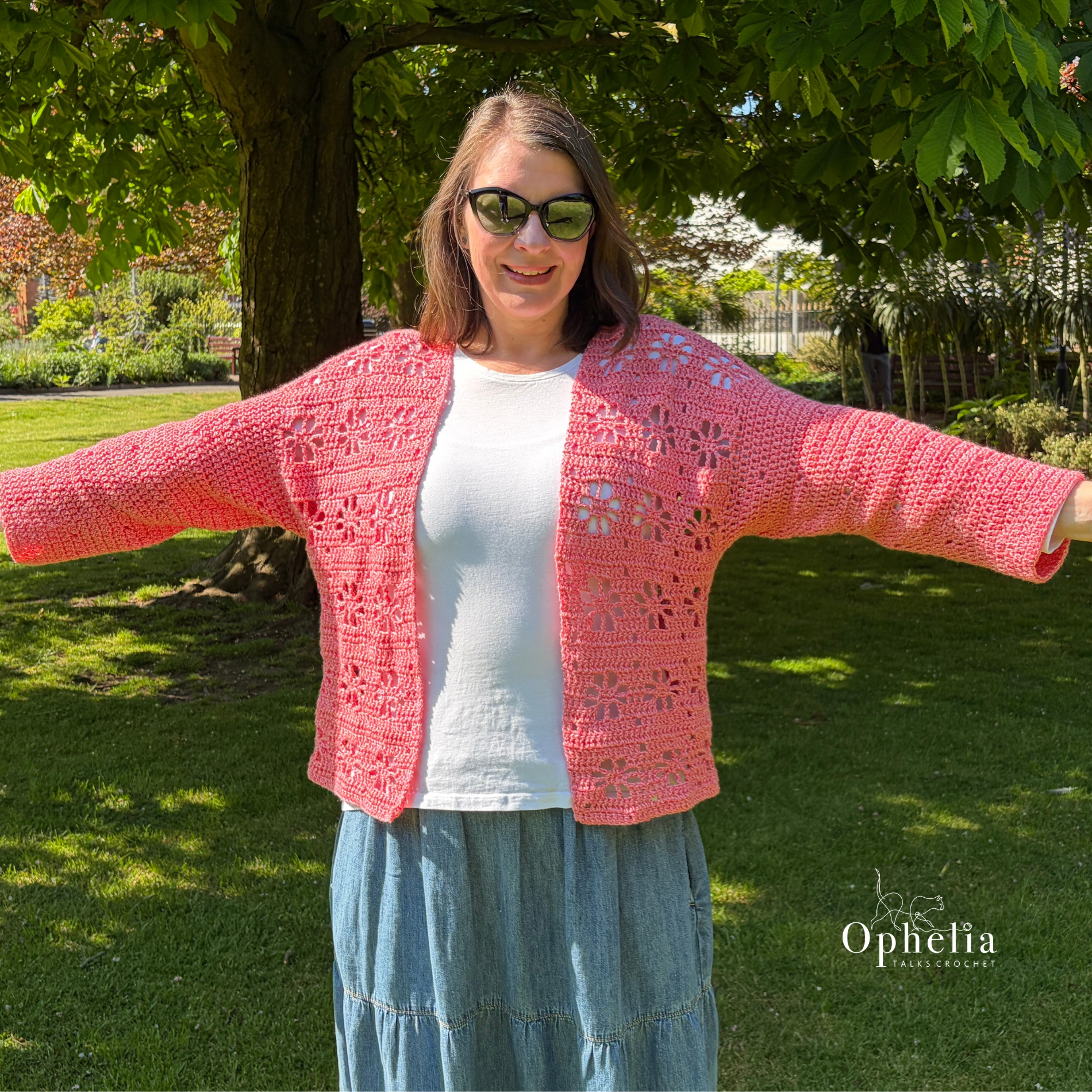 Anja wearing her begonia cardigan in the begonia colour holding her arms wide so people can see the sleeves