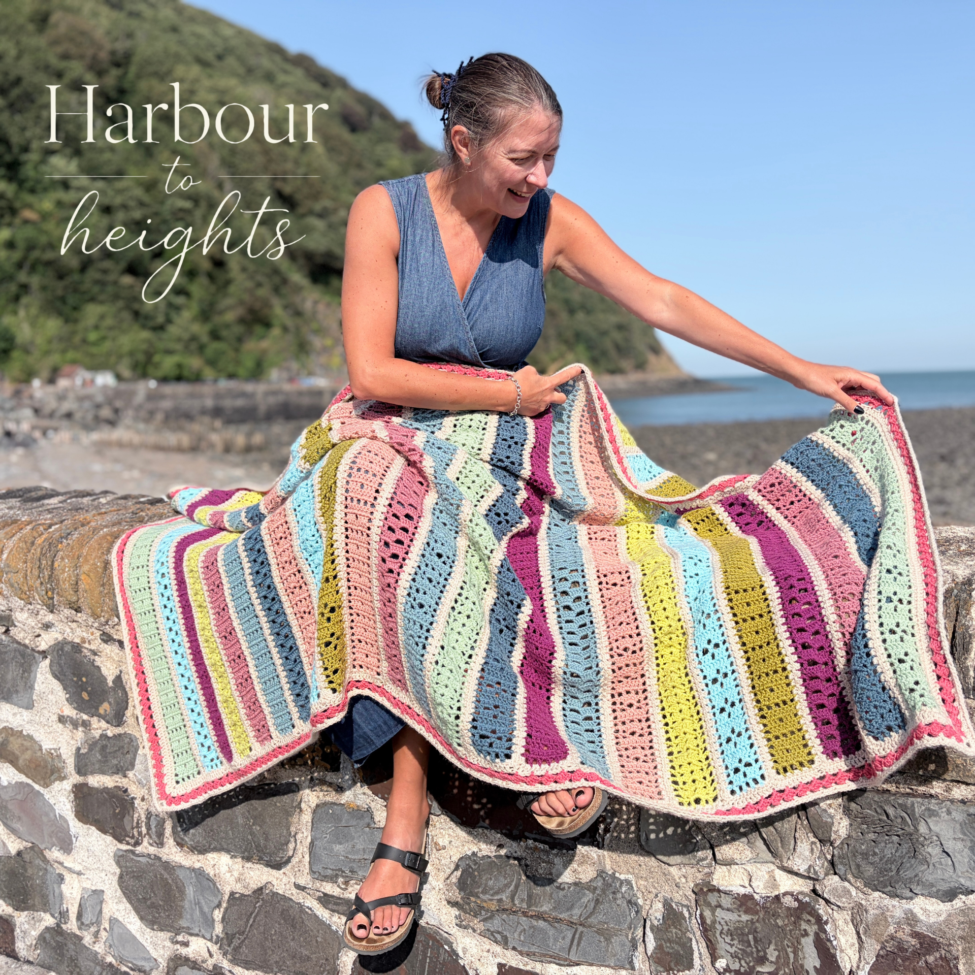 Anja showing the Harbour to Heights blanket on a harbour sea wall