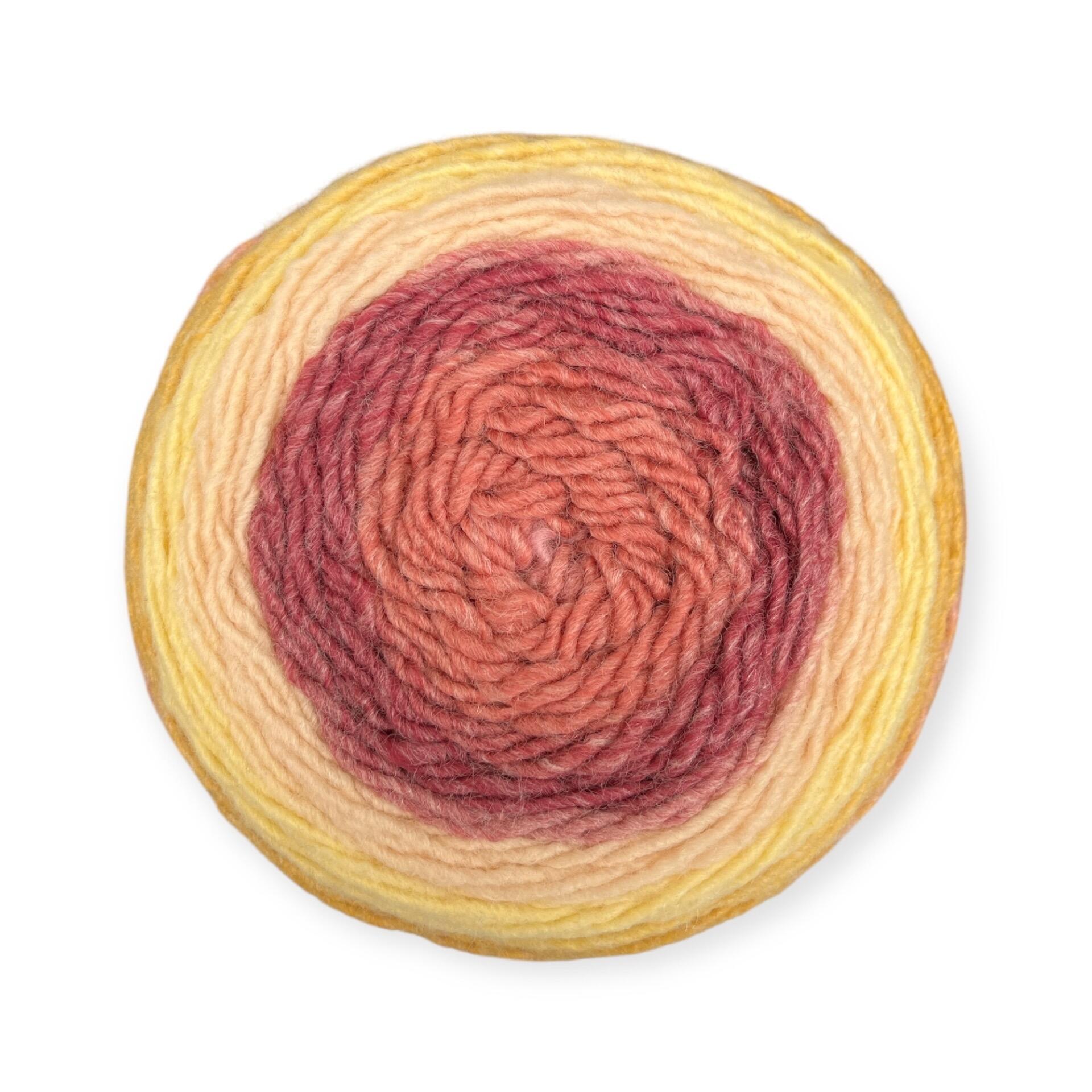 Gradient yarn cake of King Cole Curiosity DK in Cinnamon (2906), showcasing rich tones of terracotta, rust, peach, and golden yellow—ideal for knitting and crochet projects.