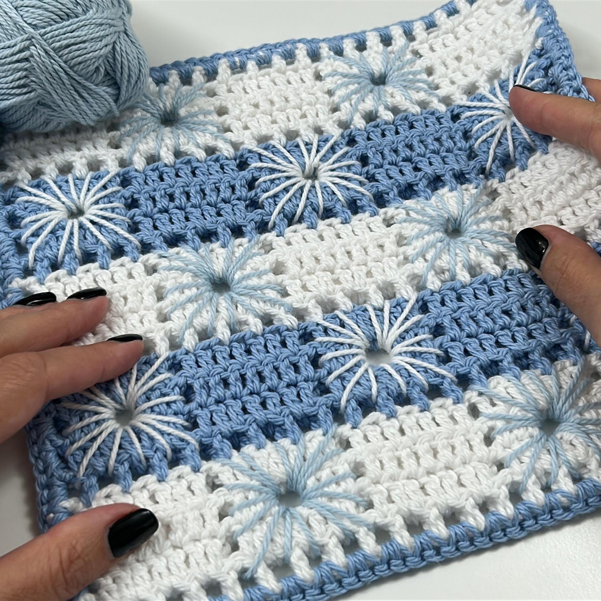 Blue and white striped crochet coaster with starburst flower stitches, handmade using Anna’s Coasters crochet pattern.