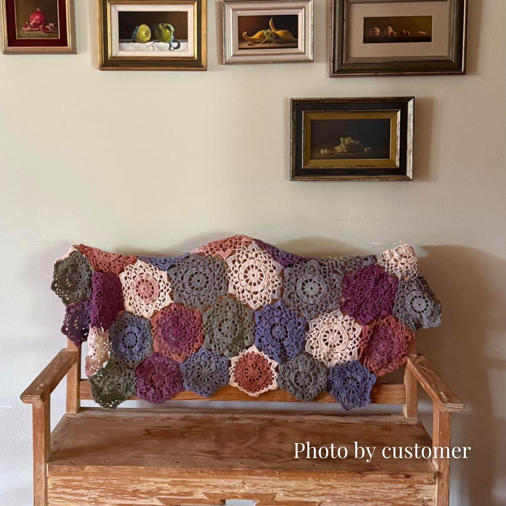 Onyx shawl draped over a bench against a wall with pictures made in King Cole Curiosity Mulberry