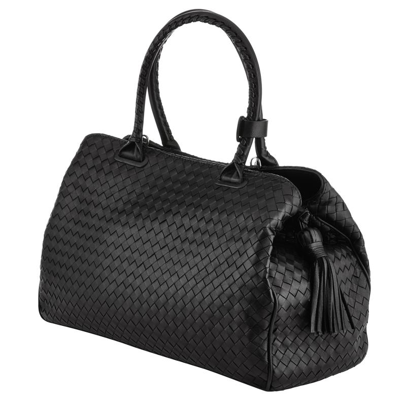 Exquisite woven leather handbag in black with double handle and pull tassel.