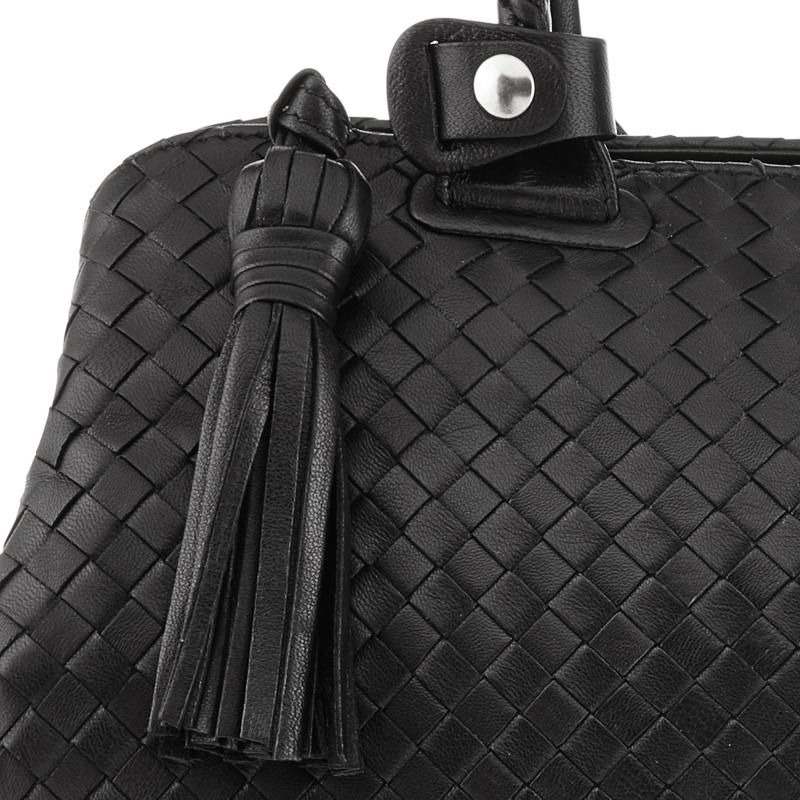 Exquisite woven leather handbag in black with double handle and pull tassel, detail.