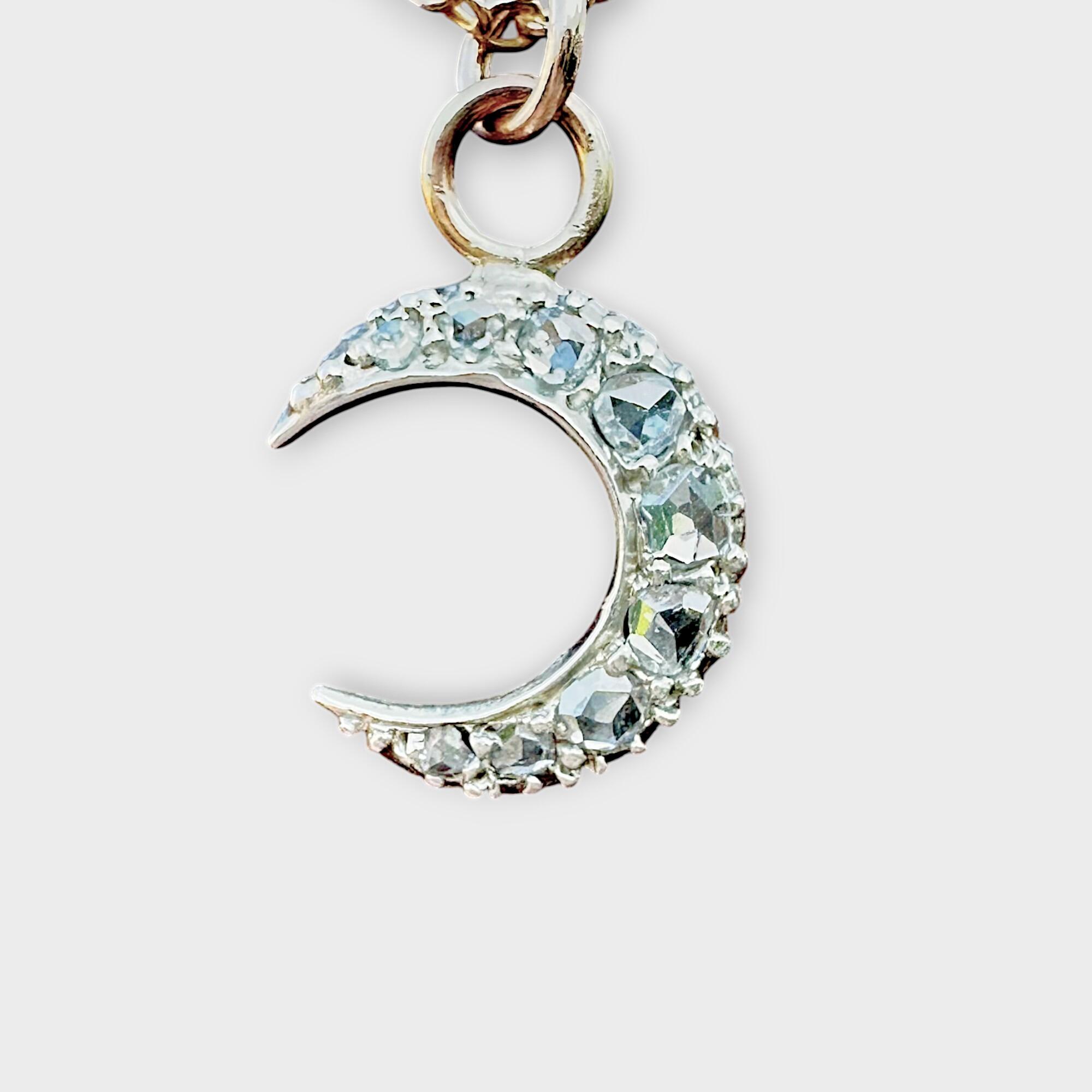Small Victorian diamond moon charm in silver and rose gold, shown against neutral background
