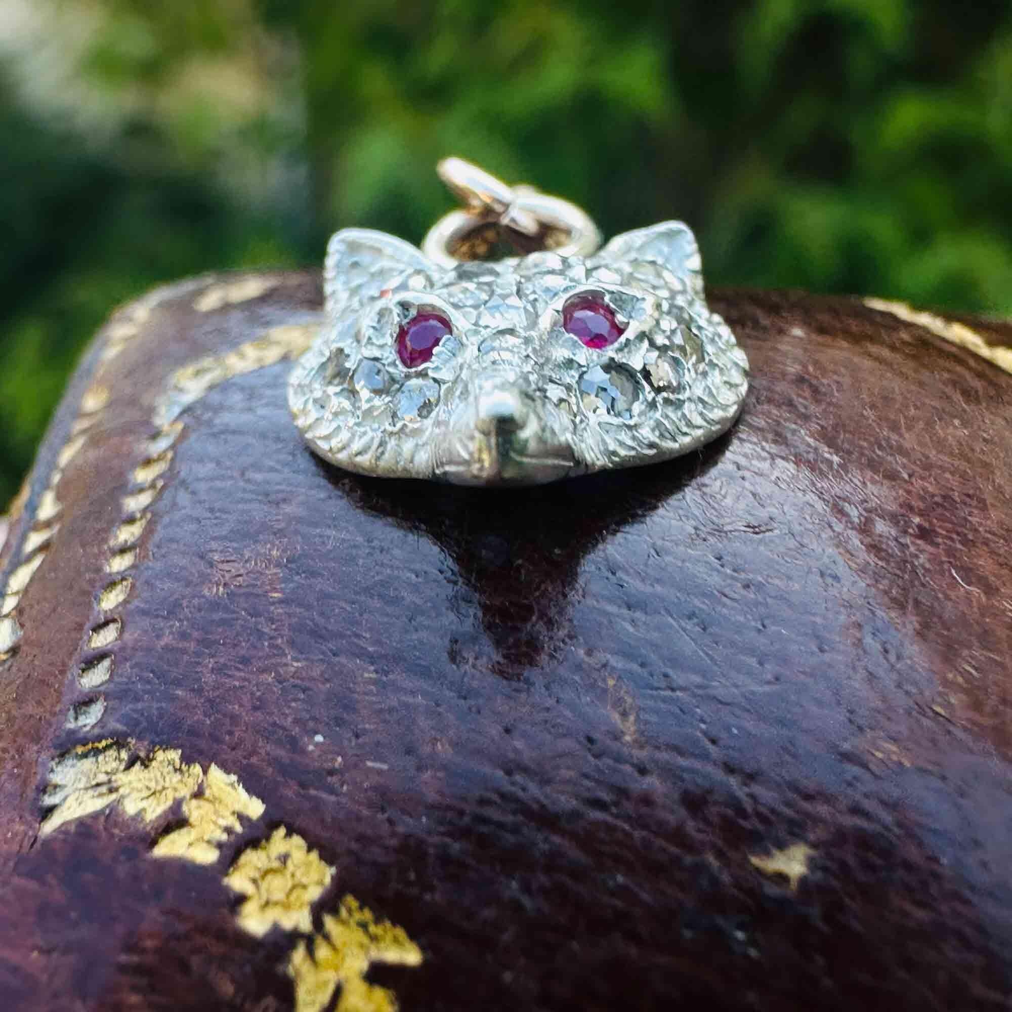 Vintage fox head pendant adorned with rose-cut diamonds in silver, accented by ruby eyes and 9ct rose gold fittings on an antique box.