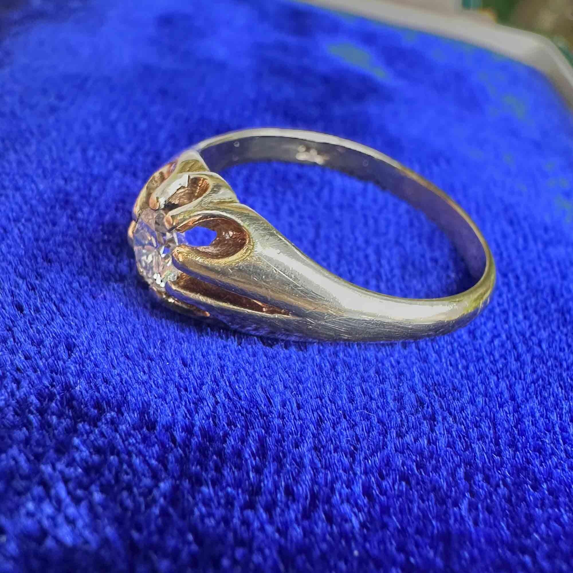 side view of gents gold diamond solitaire gypsy ring on blue velvet pad