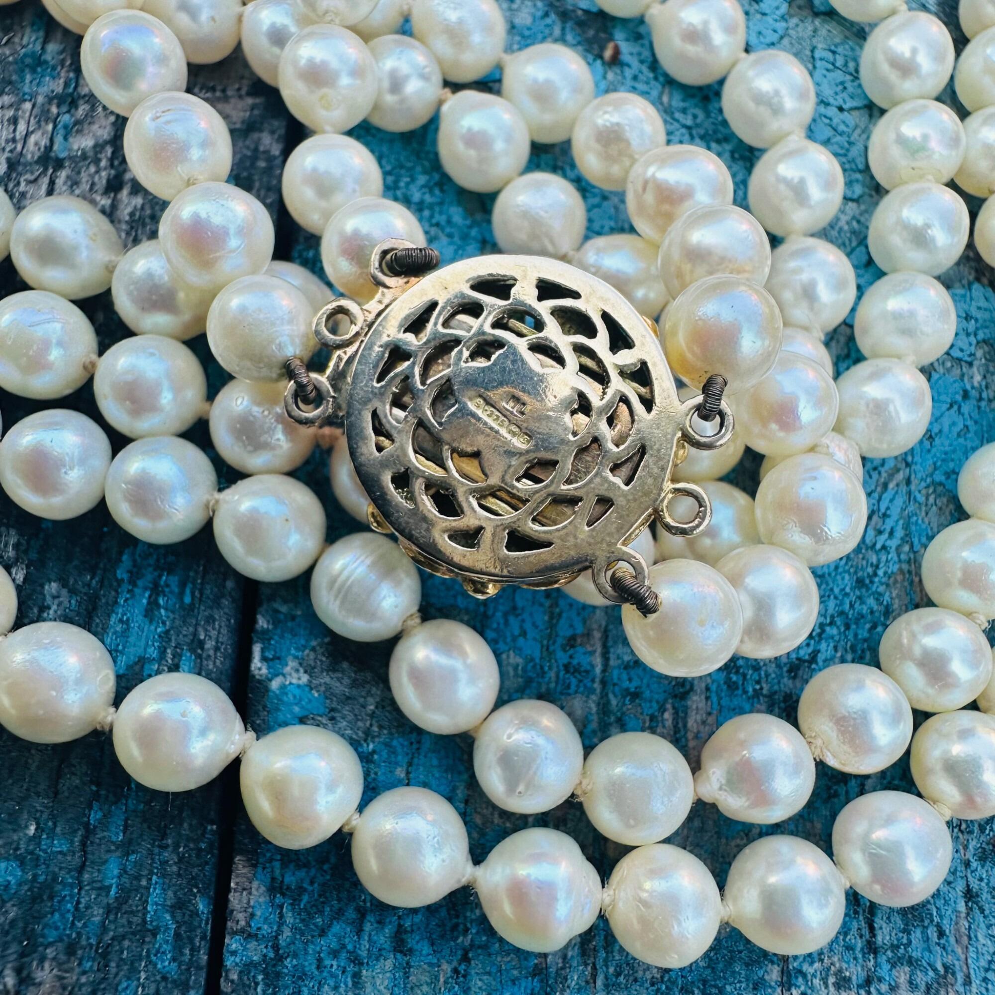 Cultured Pearl & Turquoise Necklace laying on textured surface.