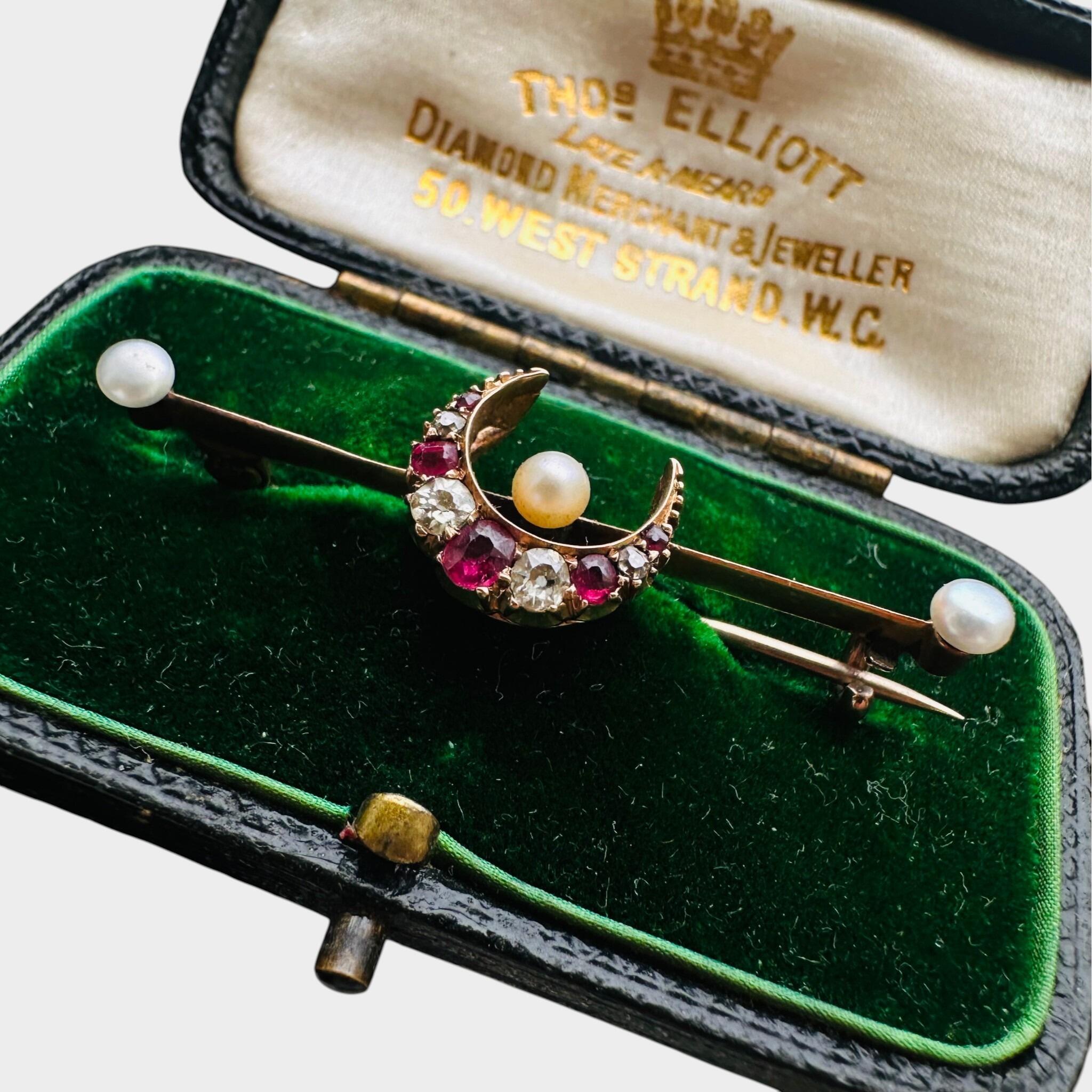 15ct Gold Diamond, Ruby & Pearl Crescent Moon Brooch displayed in green velvet antique box